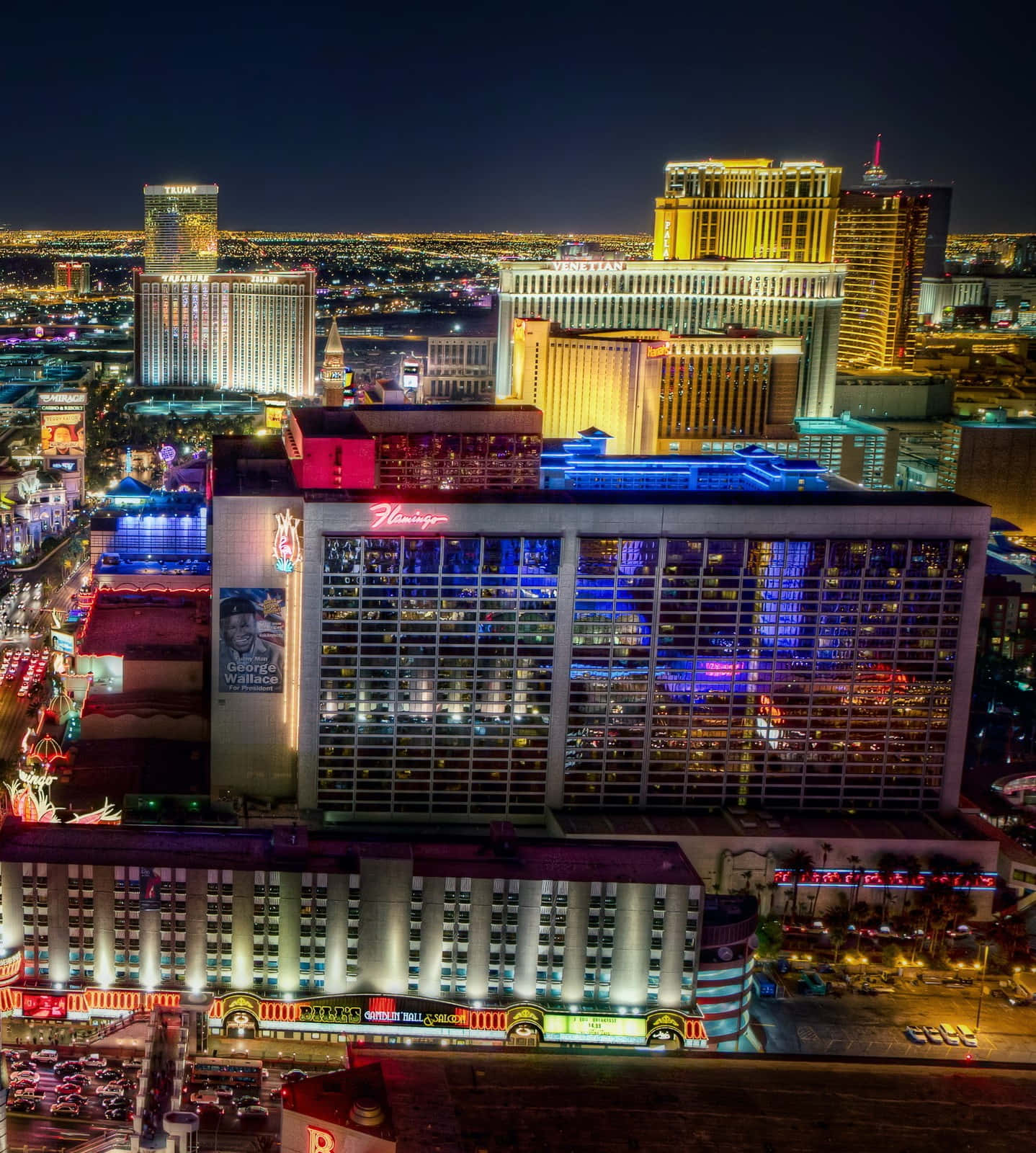 Las Vegas Phone 桌布 壁紙 — 拉斯維加斯大道夜間鳥瞰圖，霓虹燈照亮的酒店和繁華的街道在黑暗的天空下閃耀。