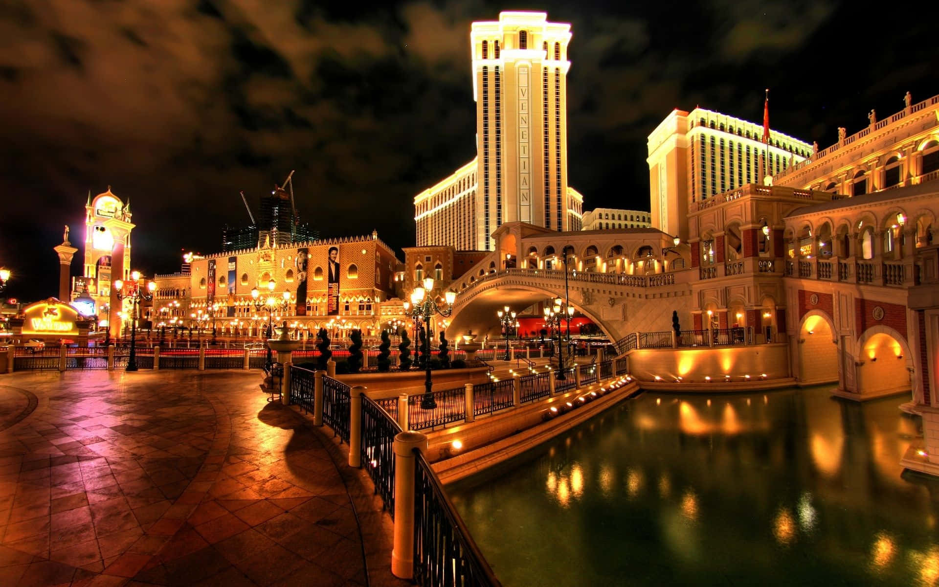 Las Vegas Skyline 桌布 壁紙 — 拉斯維加斯威尼斯人酒店運河與橋樑的璀璨夜景，溫暖的金色燈光在水面上閃爍倒映。