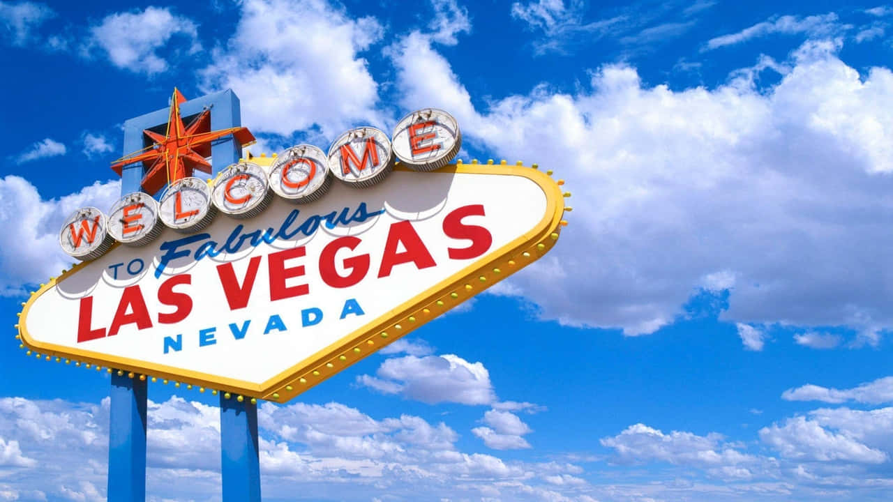 720p Las Vegas 桌布 壁紙 — 拉斯維加斯標誌性的歡迎標誌在藍天白雲下閃耀。
