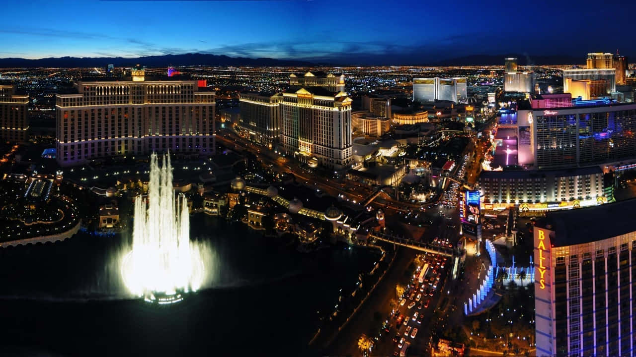 720p Las Vegas 桌布 壁紙 — 拉斯維加斯的夜間空中景觀，展示在深藍色天空下閃耀的貝拉吉奧噴泉和周圍的酒店。