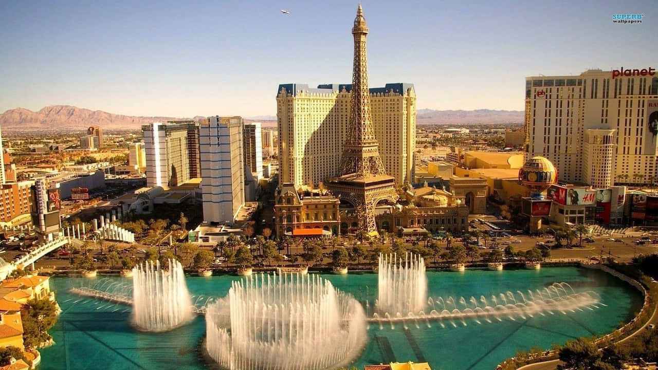 720p Las Vegas 桌布 壁紙 — 拉斯維加斯的鳥瞰圖，展示了巴黎拉斯維加斯酒店及其艾菲爾鐵塔複製品，在晴朗藍天下有充滿活力的噴泉。