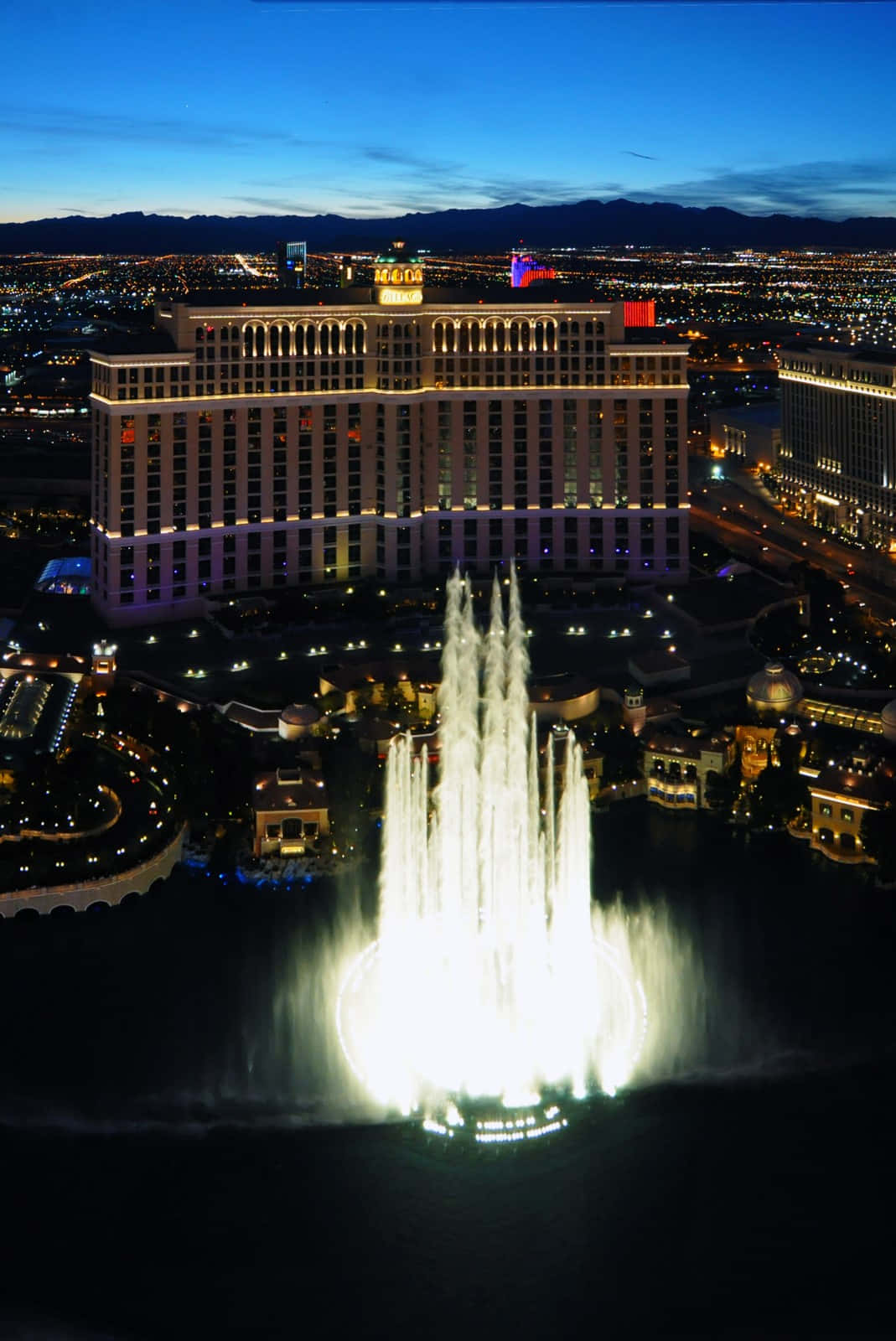Las Vegas Phone 桌布 壁紙 — 拉斯維加斯貝拉吉奧噴泉的迷人夜間鳥瞰圖，酒店在暮色天空下熠熠生輝。