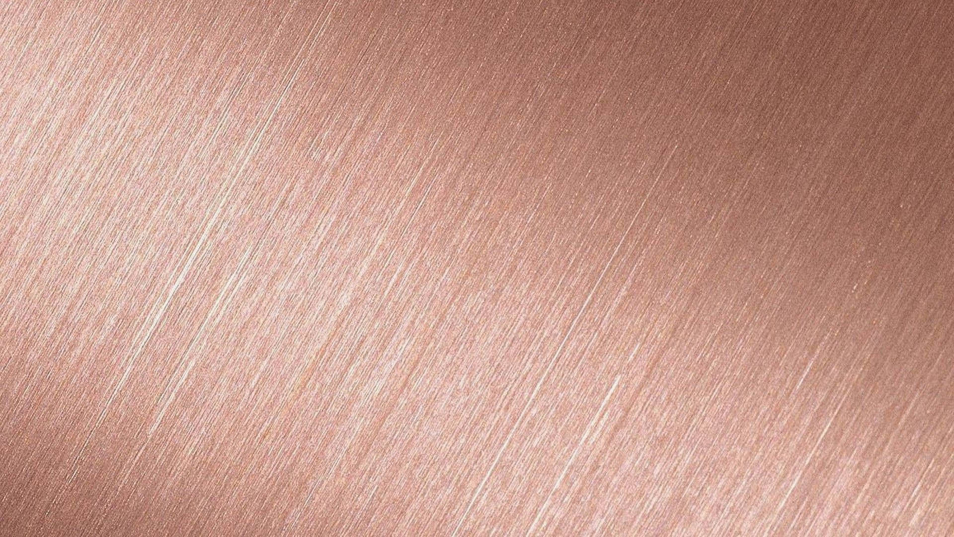 Cute Rose Gold 桌布 壁紙 — 拉絲玫瑰金金屬的特寫，帶有對角線條紋，反射柔和光線。