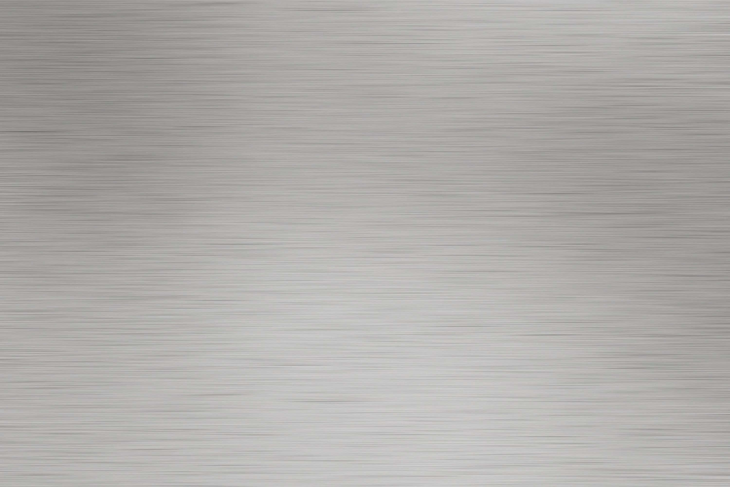 Metallic Silver 桌布 壁紙 — 拉絲金屬表面的特寫，帶有細微的平行線條，反射柔和環境光。