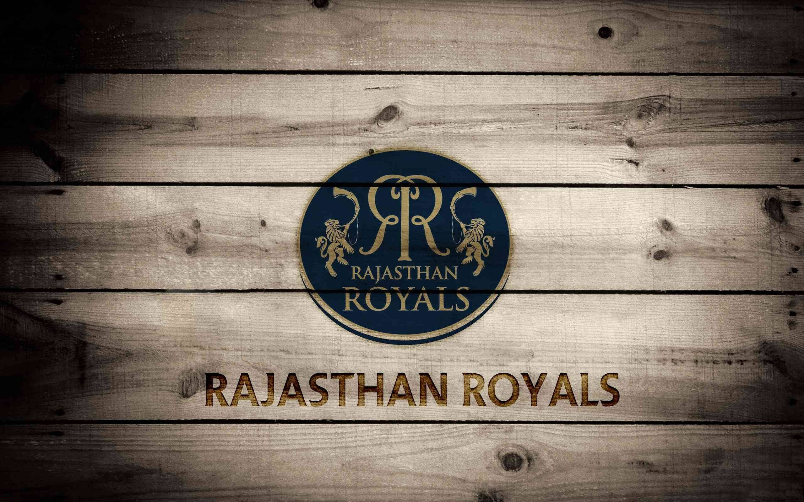 Rajasthan 桌布 壁紙 — 拉賈斯坦皇家隊金色和藍色的標誌，位於風化木板上，帶有質樸紋理。