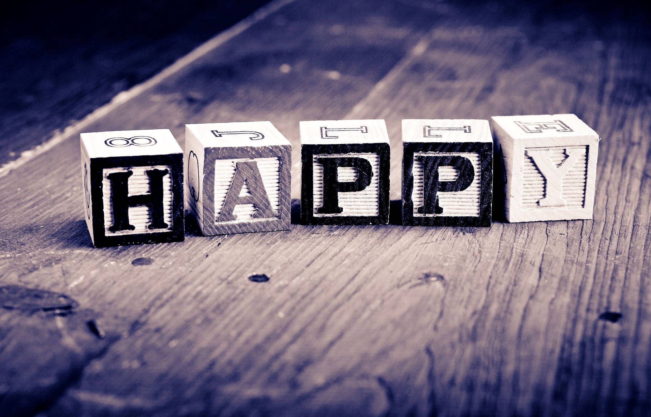 快樂 桌布 壁紙 — 拼出「HAPPY」粗體字的木塊放置在帶有復古藍色調的紋理木質表面上。
