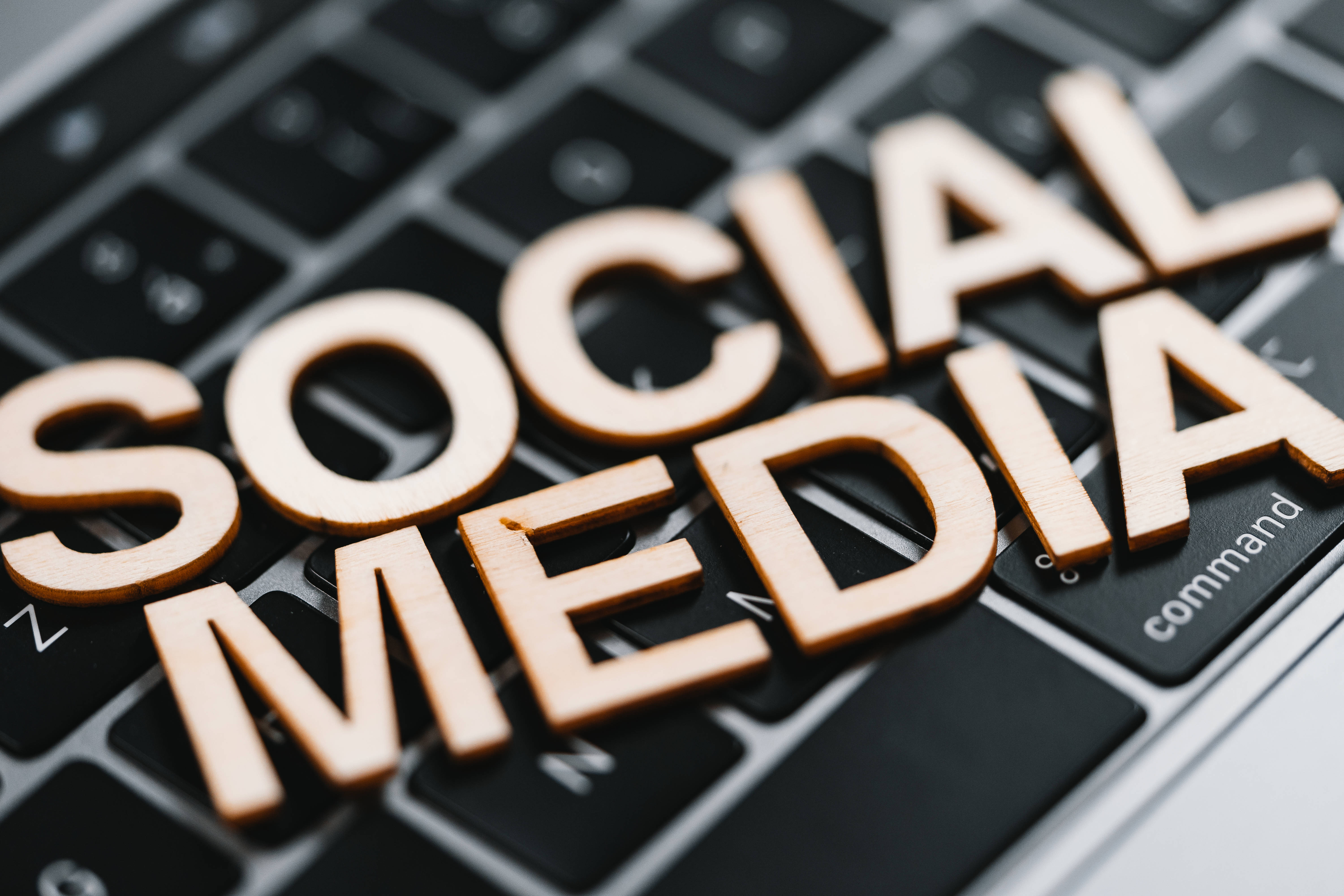 Social 桌布 壁紙 — 拼出 social media 的木製字母放在黑色鍵盤上，景深較淺。