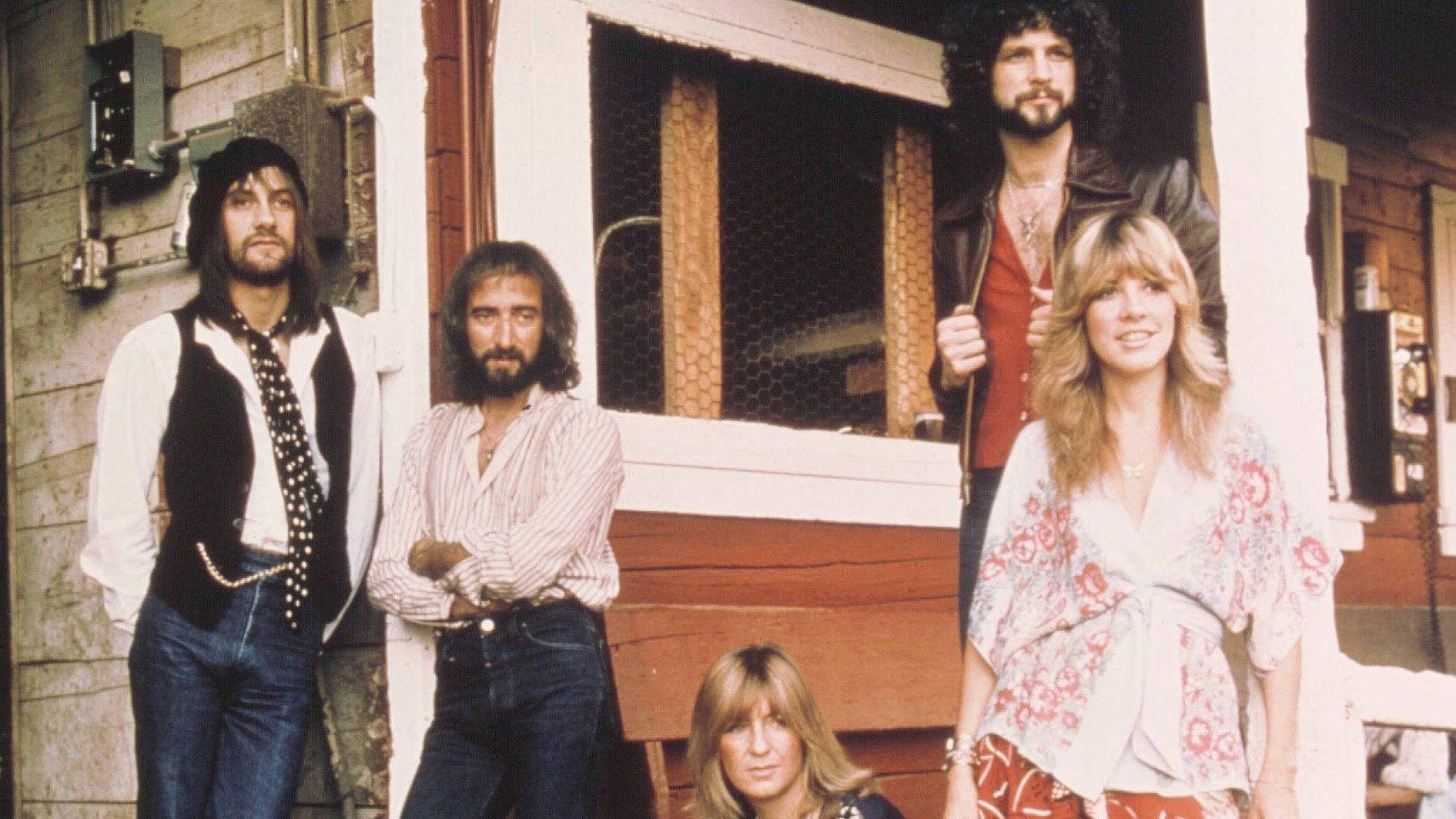 band 桌布 壁紙 — 搖滾樂團 Fleetwood Mac 的四名成員穿著 1970 年代的服裝，在質樸的木門廊上隨意擺姿勢。