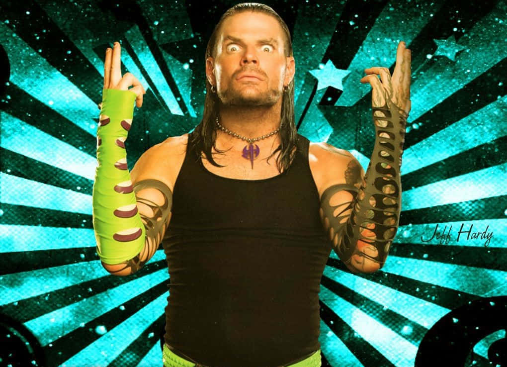 WWE 桌布 壁紙 — 摔角手 Jeff Hardy 以狂野的眼神和刺青手臂，在充滿活力的藍綠色星爆背景前擺姿勢。