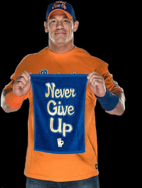 摔角 桌布 壁紙 — 摔角手 John Cena 微笑著舉起一條印有「Never Give Up」的藍色毛巾，並做出OK手勢。