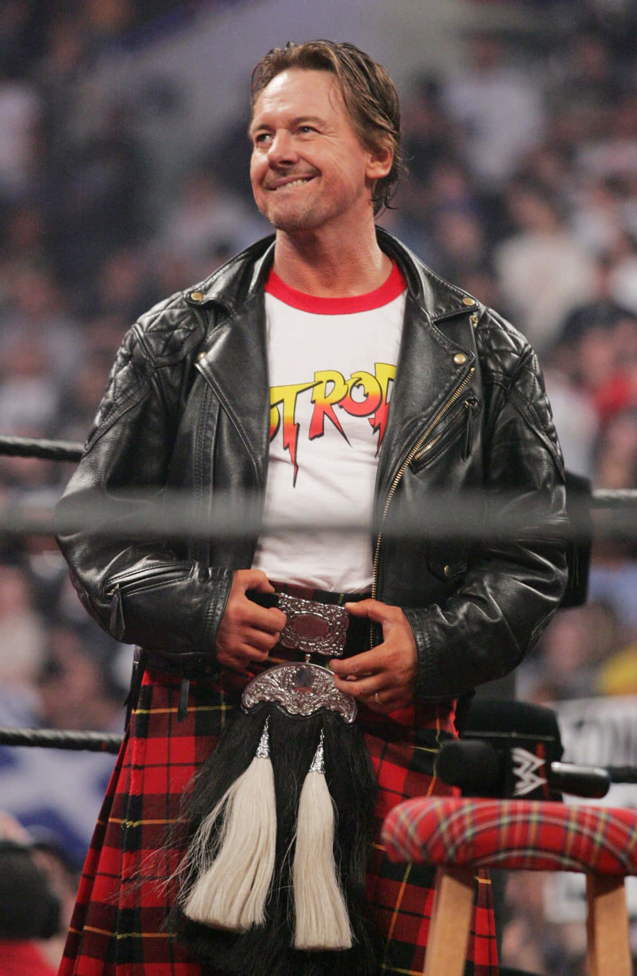 WWE 桌布 壁紙 — 摔角手 Shawn Michaels 在摔角擂台上自信地微笑，身穿皮夾克和帶有銀色扣環的紅色蘇格蘭裙。