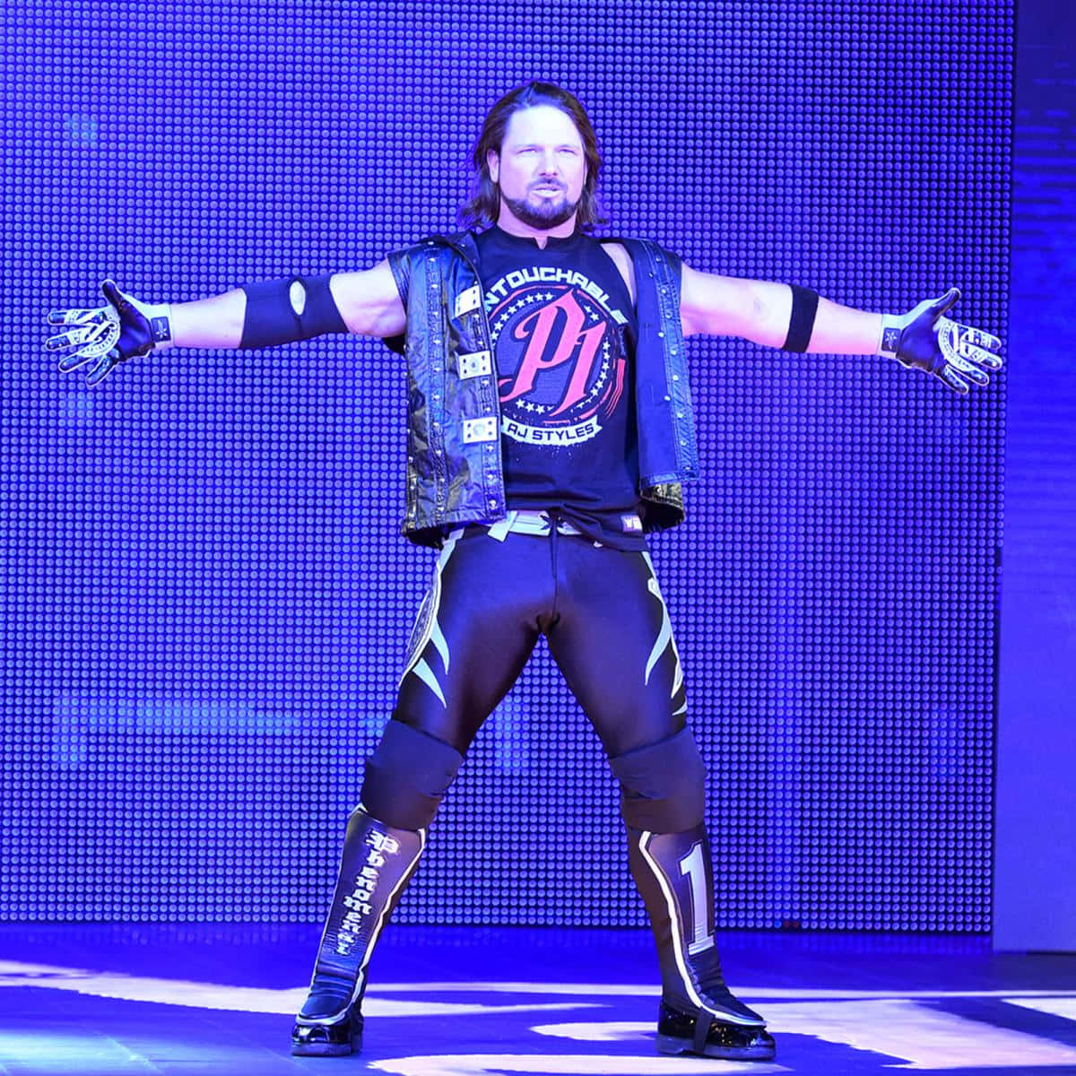 WWE 桌布 壁紙 — 摔角手AJ Styles在充滿活力的藍色燈光下，雙臂大開，在舞台上擺出自信的姿勢。