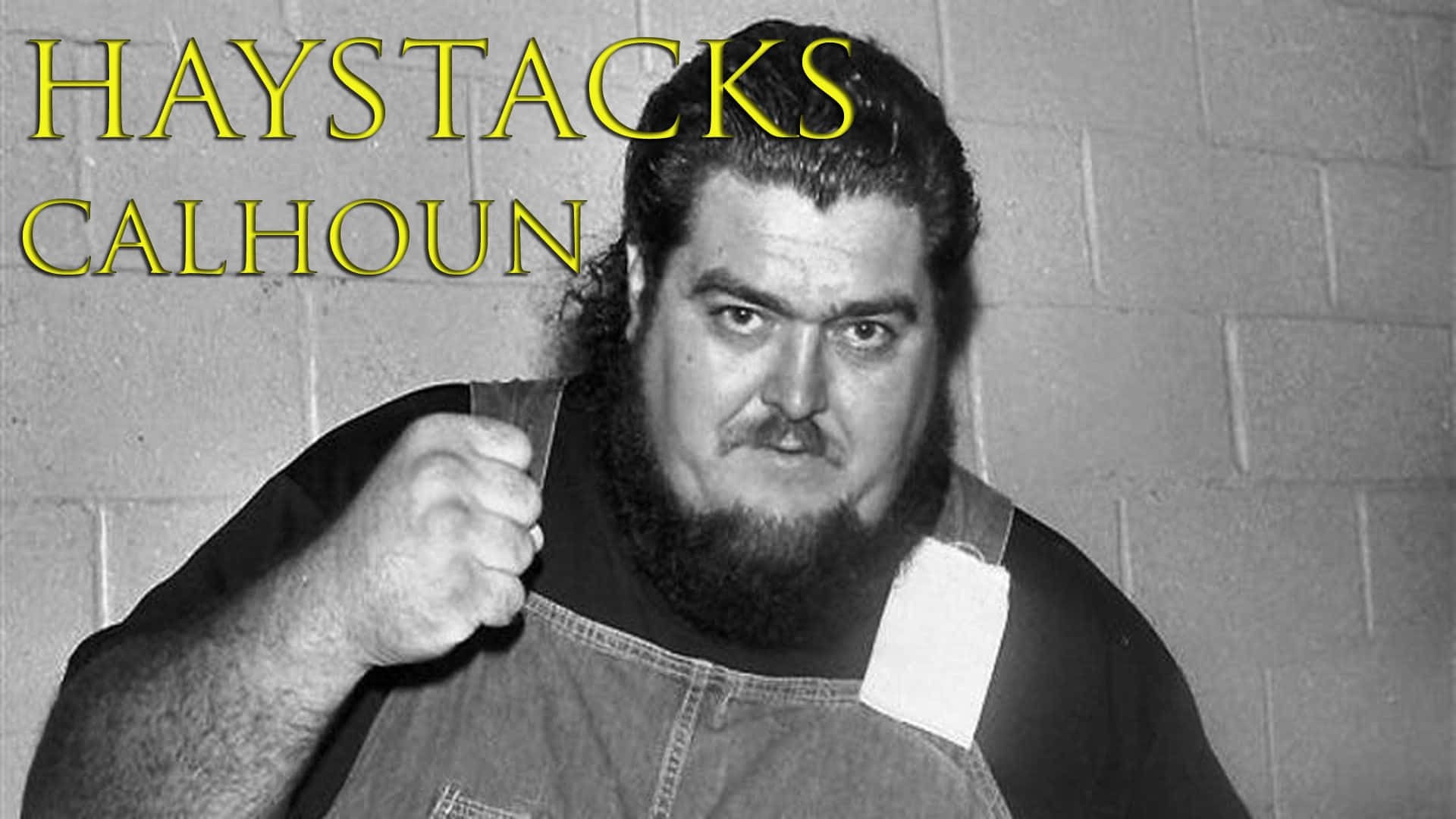 黑白 桌布 壁紙 — 摔角手Haystacks Calhoun在煤渣磚牆前握拳擺姿勢的黑白肖像。