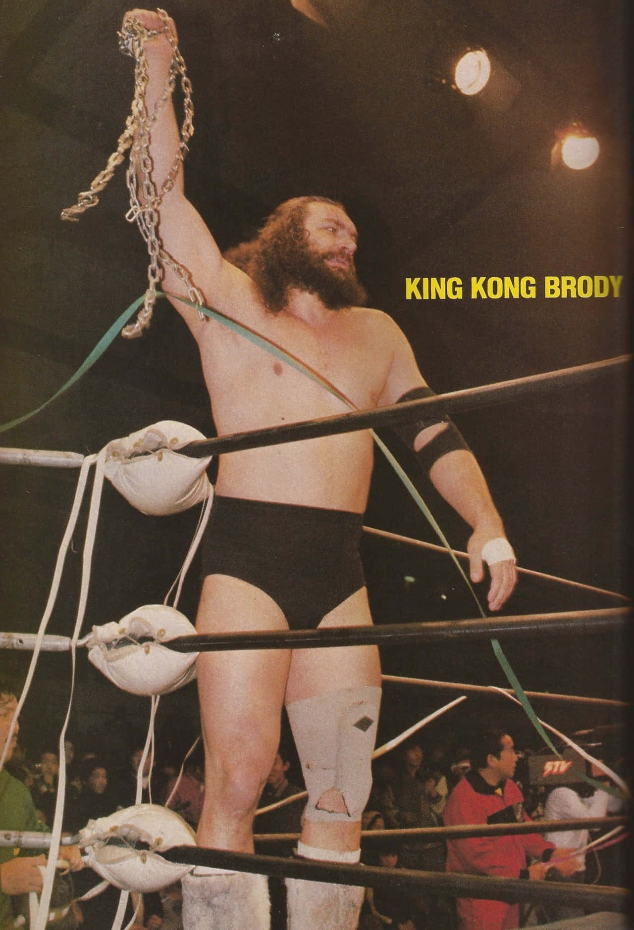 WWE 桌布 壁紙 — 摔角手King Kong Brody在明亮的場館燈光下，高舉鐵鏈，勝利地站在擂台上。