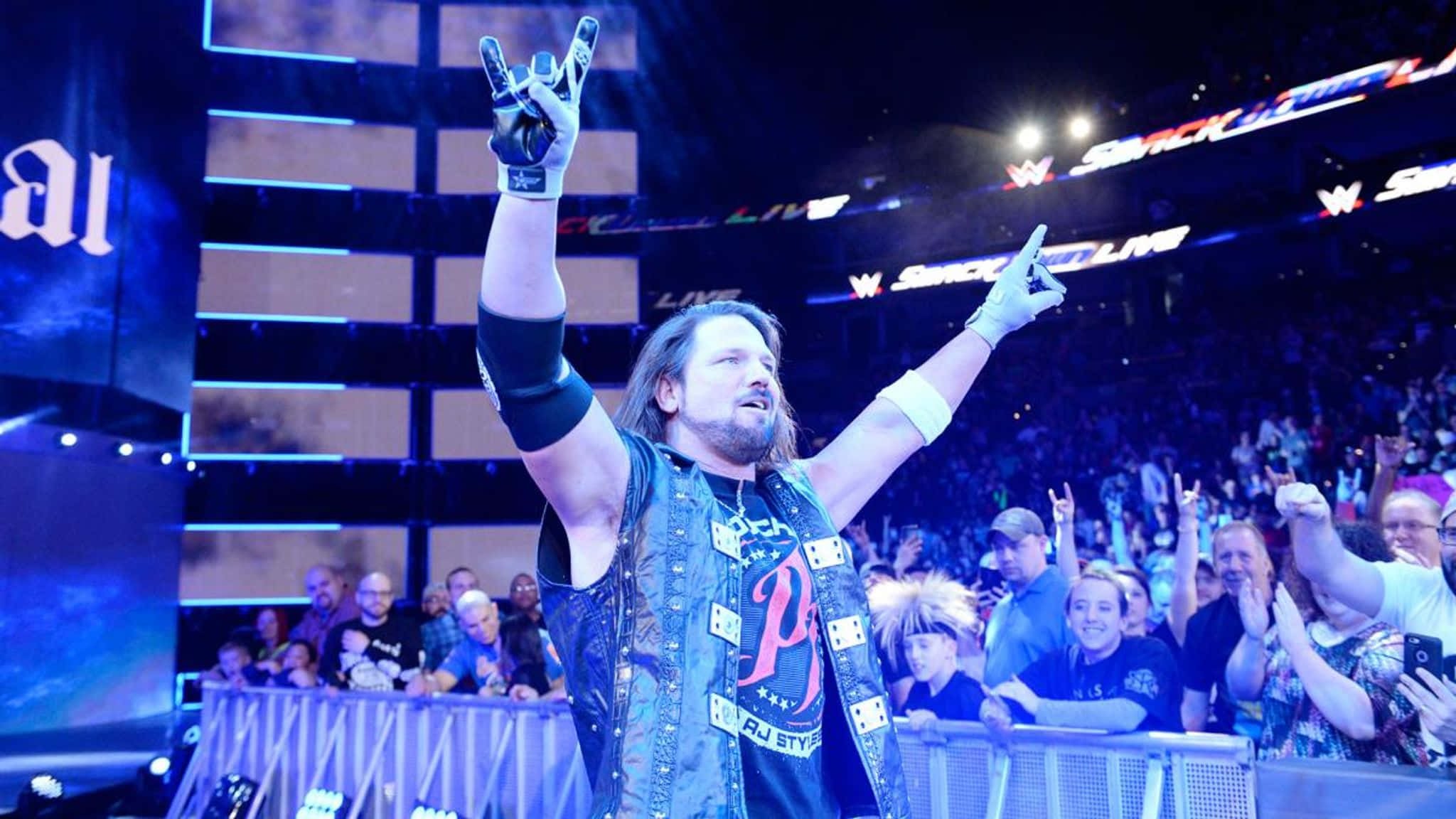 WWE 桌布 壁紙 — 摔角手蘭迪·奧頓在燈光明亮的場館中高舉雙臂慶祝勝利，粉絲們歡呼雀躍。