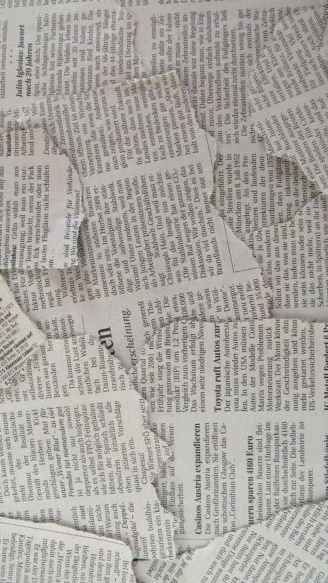 撕碎的德文報紙碎片，有標題和文字。 — 柔和美學 GIF 壁紙