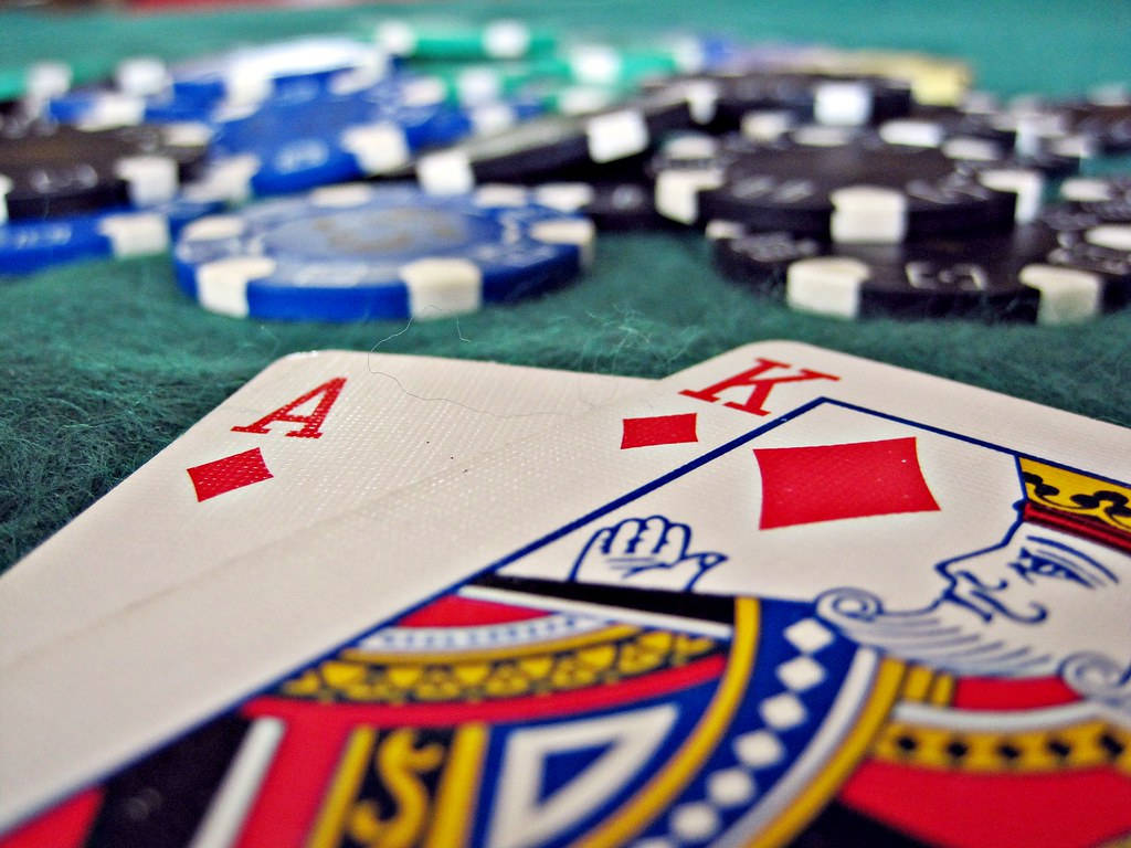 Casino 桌布 壁紙 — 撲克牌A和K方塊的特寫，在綠色絨面桌上，周圍有籌碼。