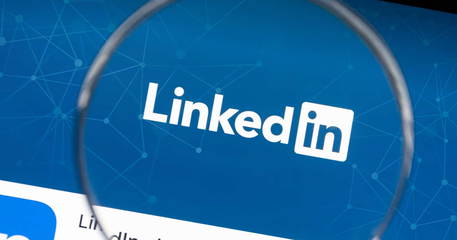 Linkedin Logo 桌布 壁紙 — 放大鏡清晰地聚焦在藍色網絡圖案背景上的白色LinkedIn標誌。