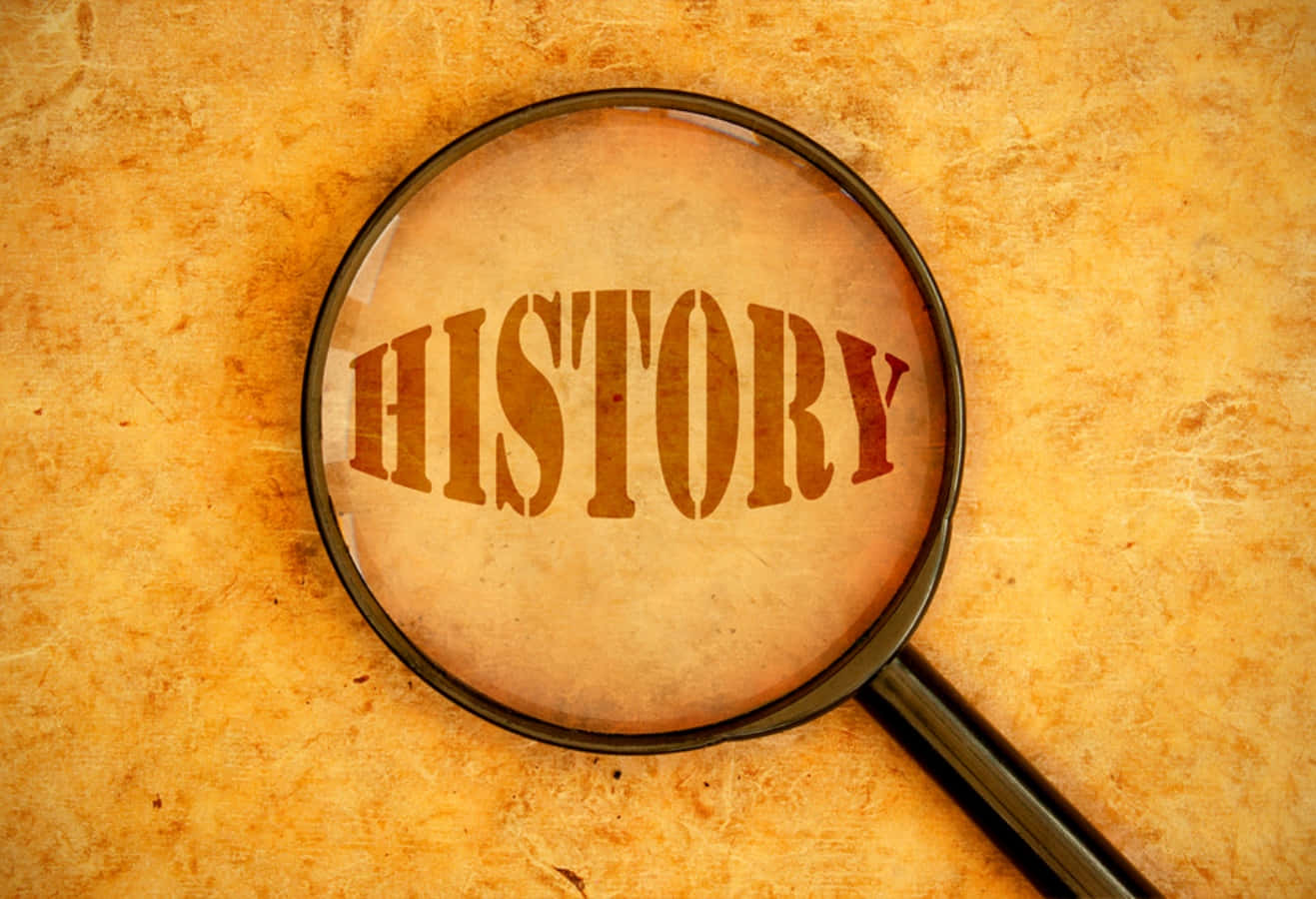 history 桌布 壁紙 — 放大鏡聚焦在印在舊羊皮紙上的「歷史」一詞，背景為有紋理的黃色。
