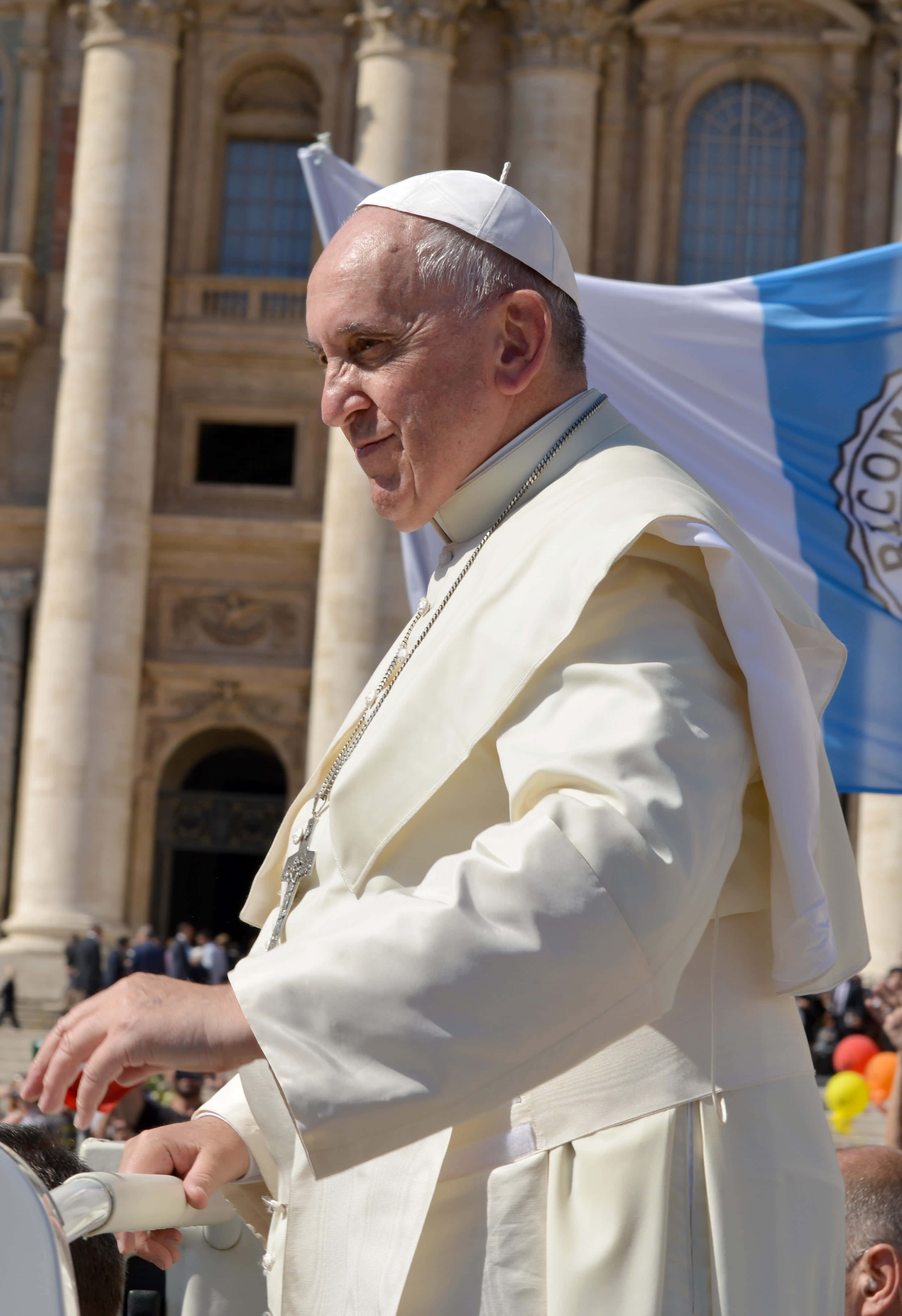 Pope Francis 桌布 壁紙 — 教宗方濟各在明亮的日光下，乘坐白色教宗座駕經過宏偉的石造大教堂，露出溫暖的笑容。