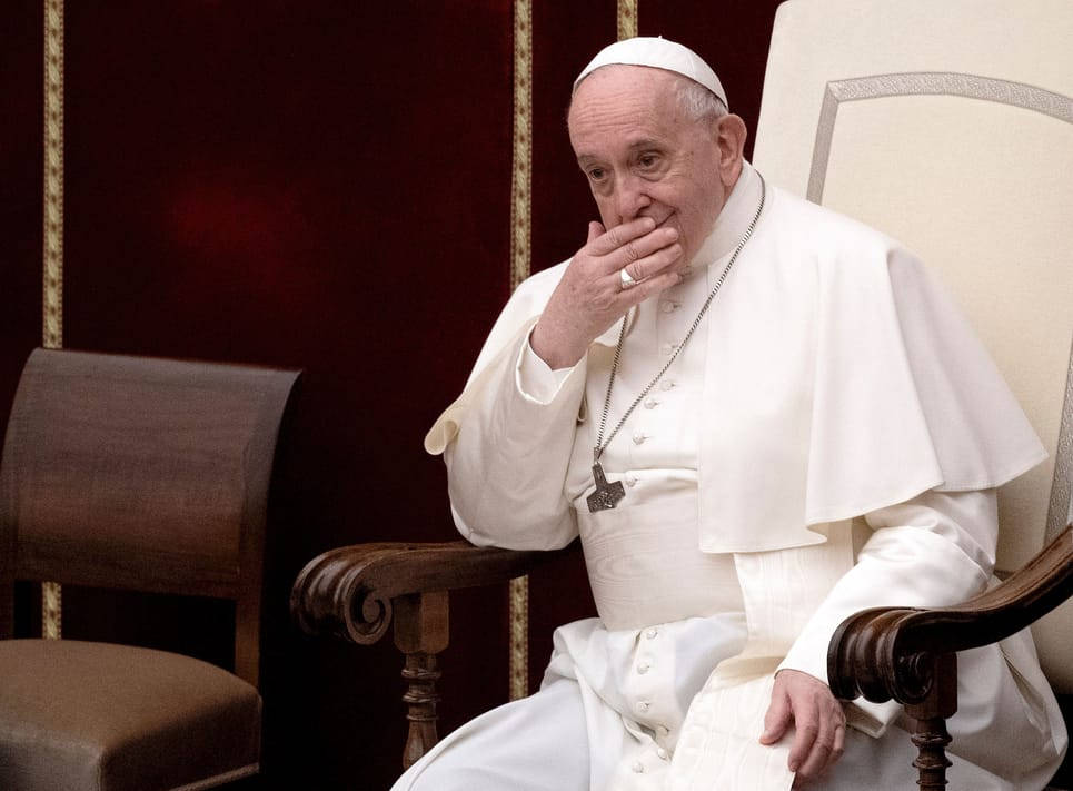 Catholic 桌布 壁紙 — 教宗方濟各坐在木椅上，身穿白色教宗袍並戴著戒指，手掩嘴巴，陷入靜默沉思的時刻。