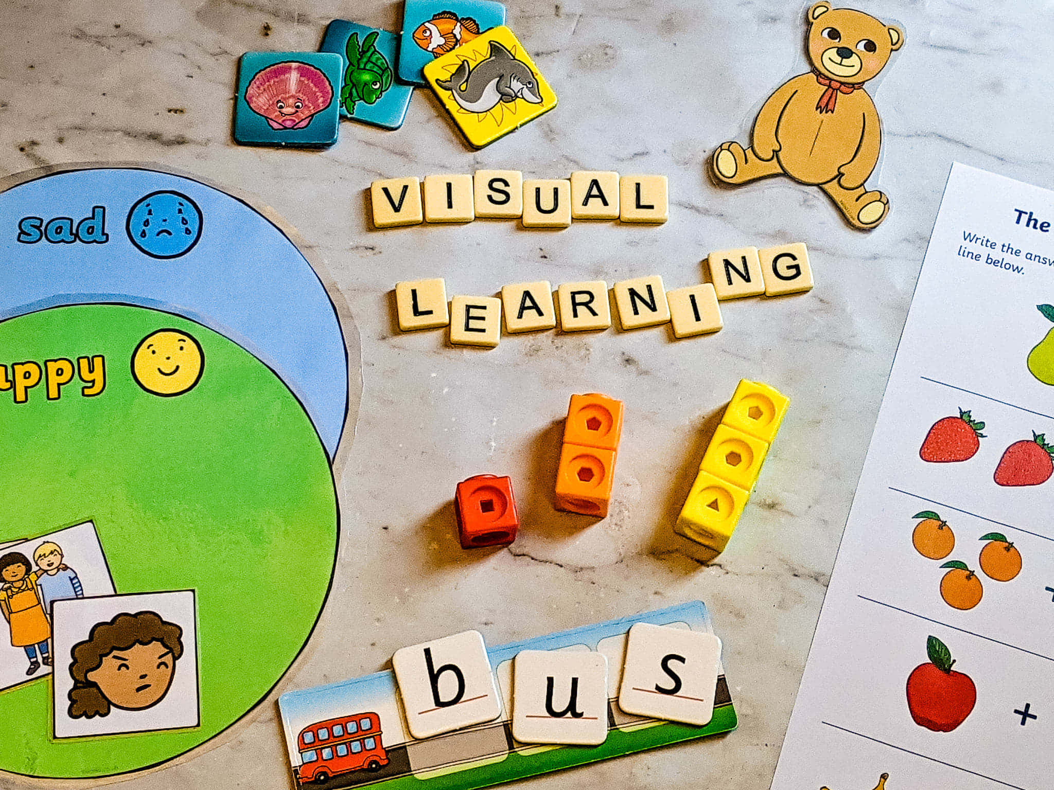 Learning 桌布 壁紙 — 教育玩具和閃卡用於視覺學習，散落在大理石表面上，配有彩色積木和情緒圖表。