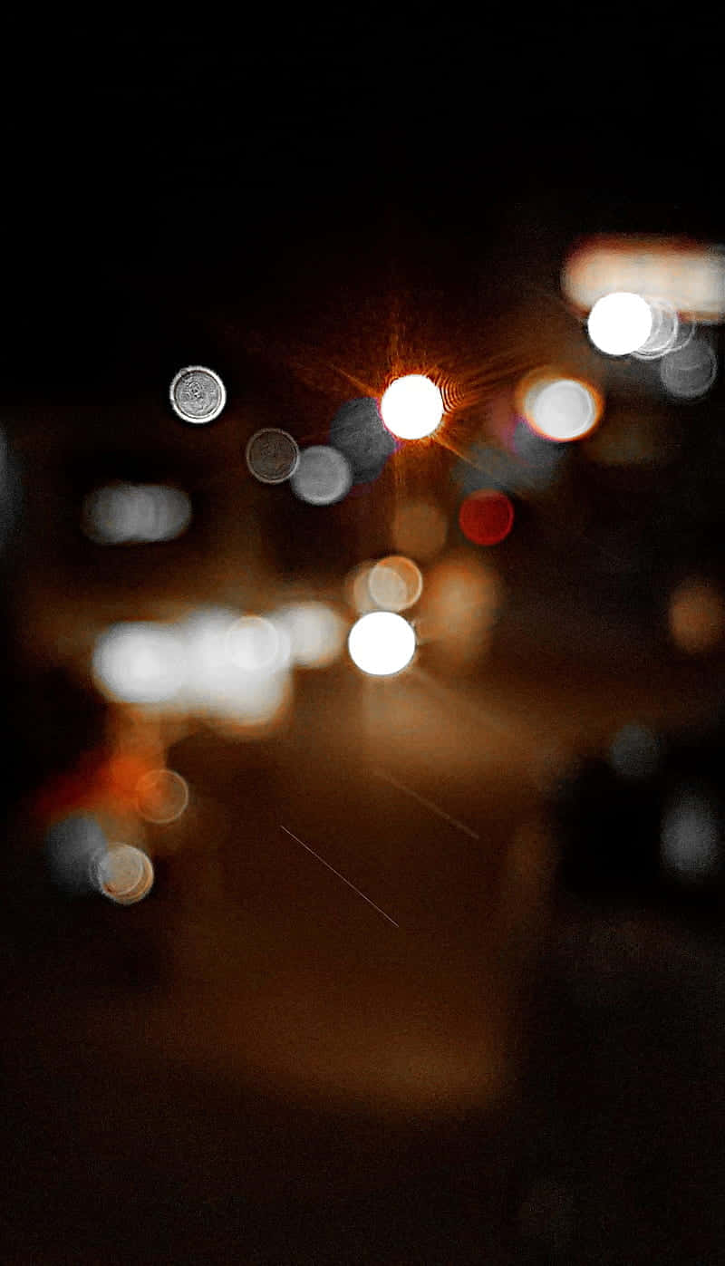 Black Blur 桌布 壁紙 — 散景燈光在漆黑的夜街上溫暖地發光，營造出夢幻般的城市夜景。