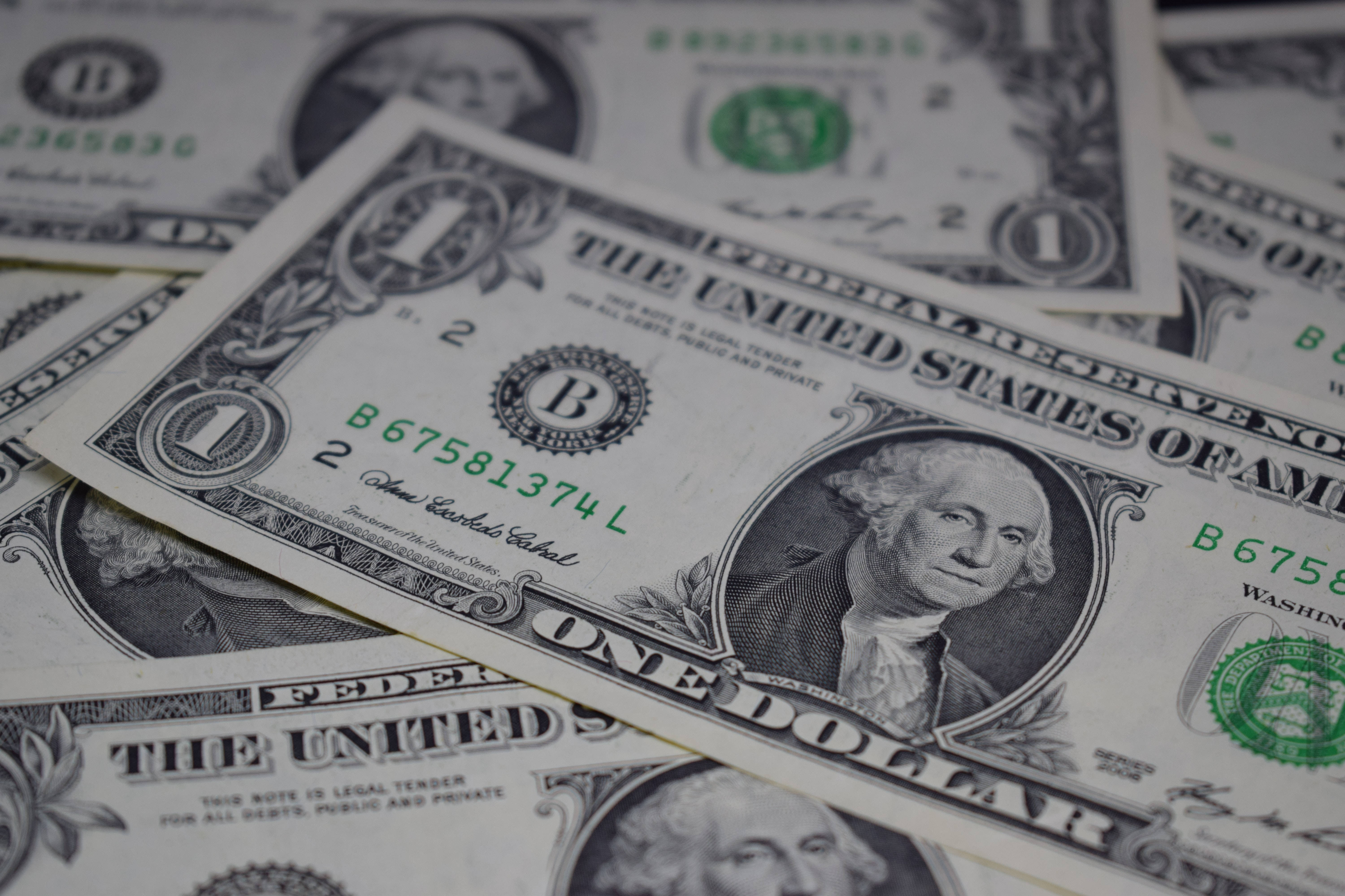 No Money 桌布 壁紙 — 散落的一美元鈔票特寫，喬治·華盛頓的肖像和綠色印章清晰對焦。