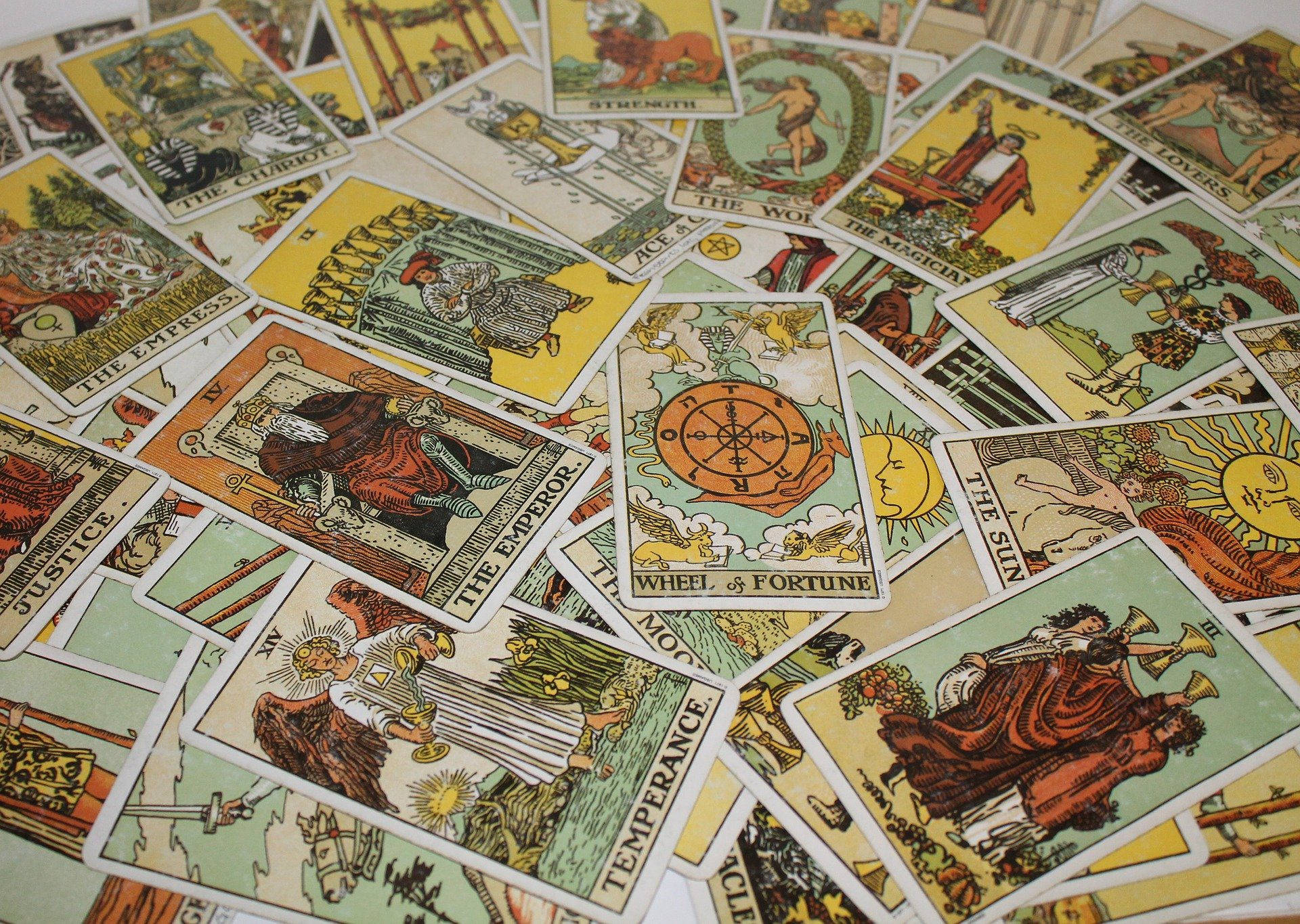 Tarot Card 桌布 壁紙 — 散落的復古塔羅牌排列，以溫暖的大地色調呈現豐富的神話人物和象徵性圖案。
