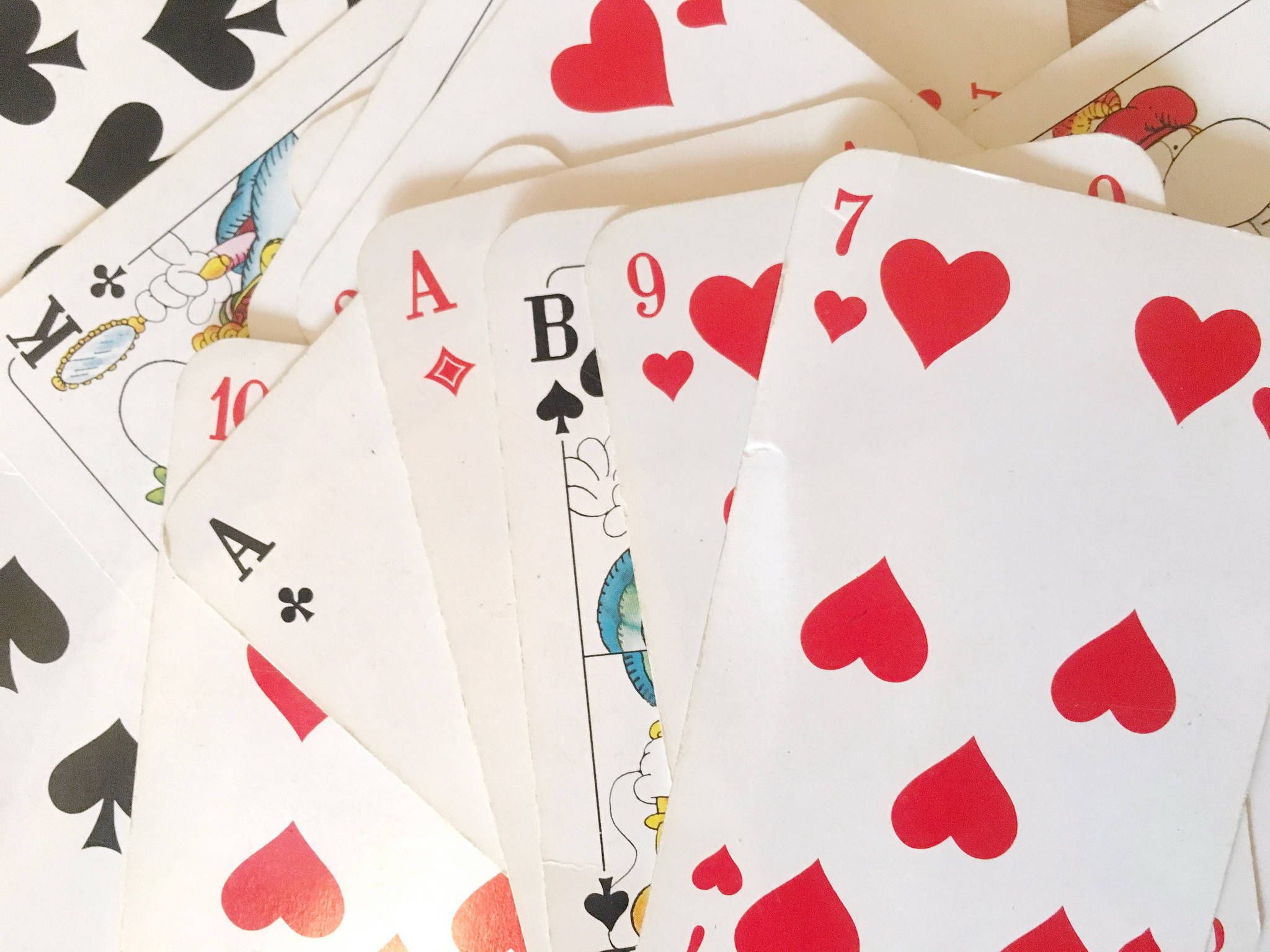 Playing Cards 桌布 壁紙 — 散開的撲克牌扇，紅心與黑桃，白色背景。