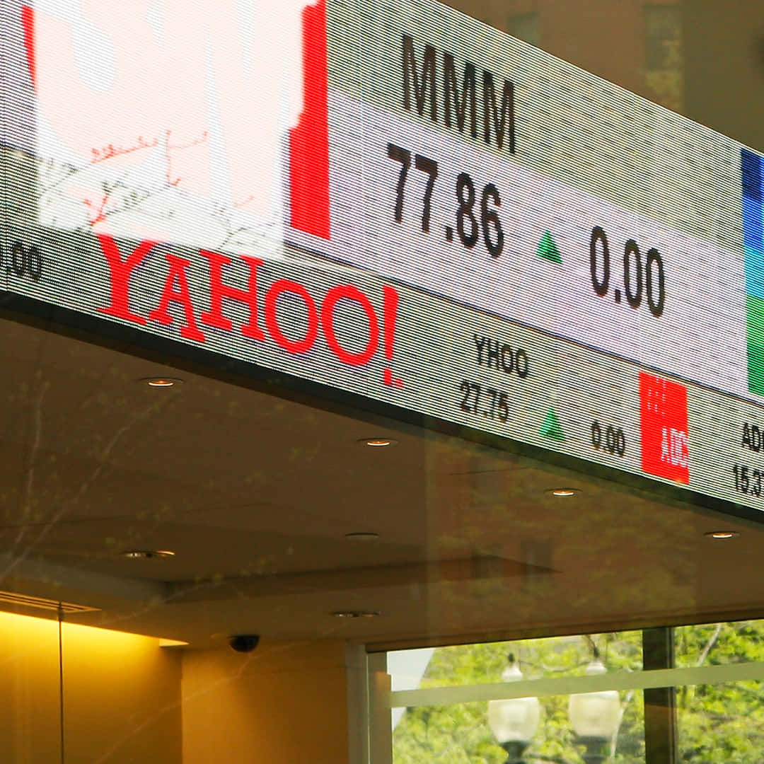 Yahoo 桌布 壁紙 — 數位股票行情顯示器的特寫，顯示Yahoo和MMM的股價，並有綠色箭頭表示上漲。