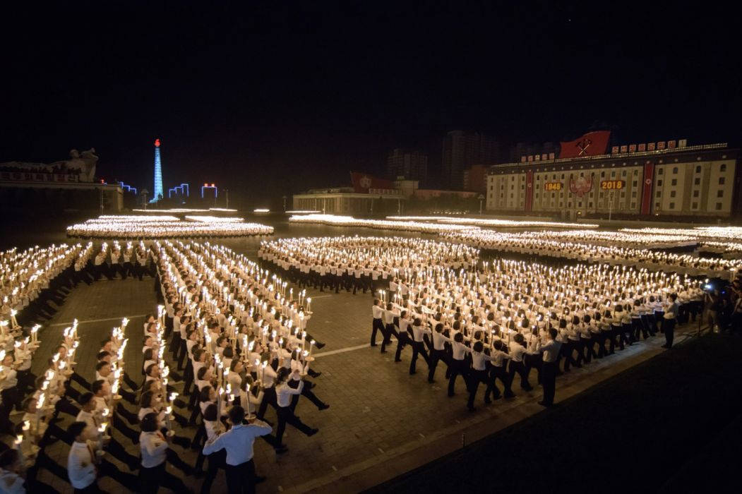 韓國 桌布 壁紙 — 數千人在夜間以同步隊形遊行，手持點燃的蠟燭，在黑暗的天空下廣闊的城市廣場上。
