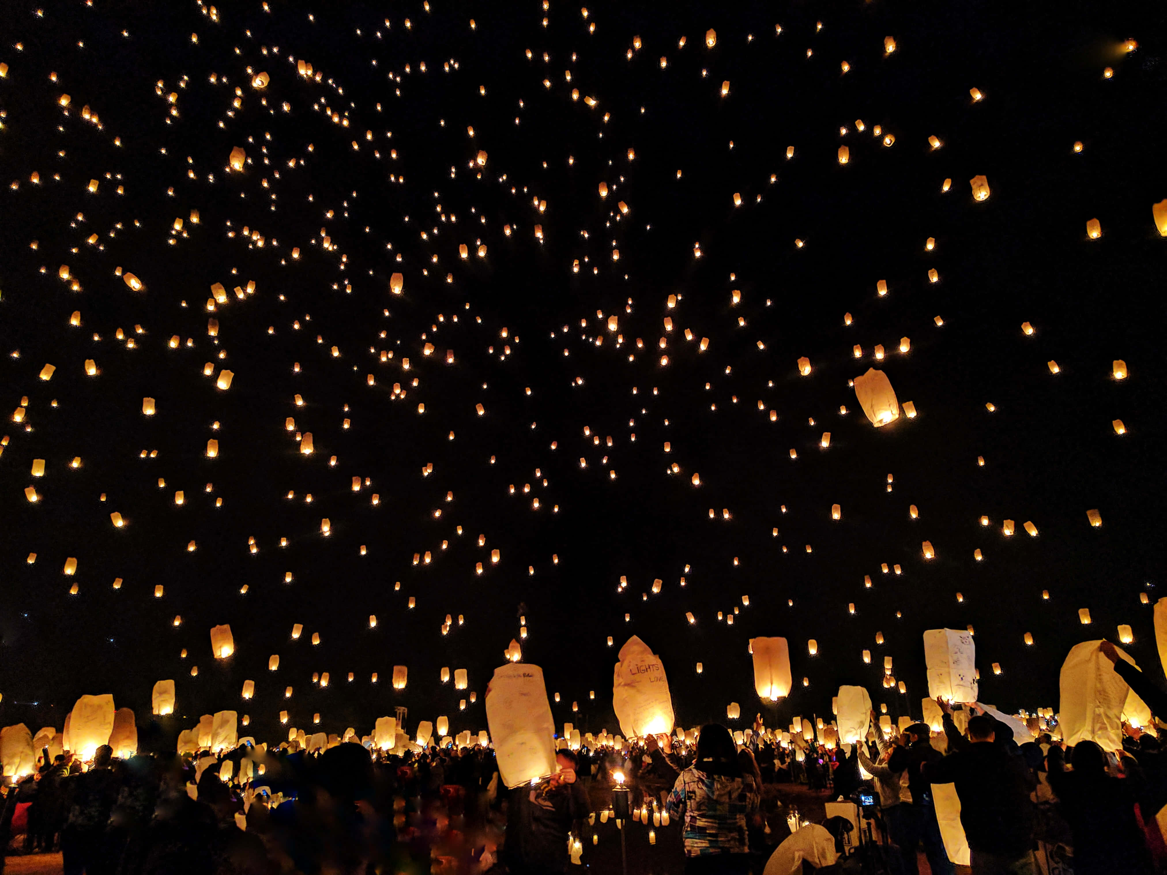 Lantern 桌布 壁紙 — 數千盞發光的天燈在黑暗的夜晚升起，人群在神奇的慶祝活動中將它們釋放。