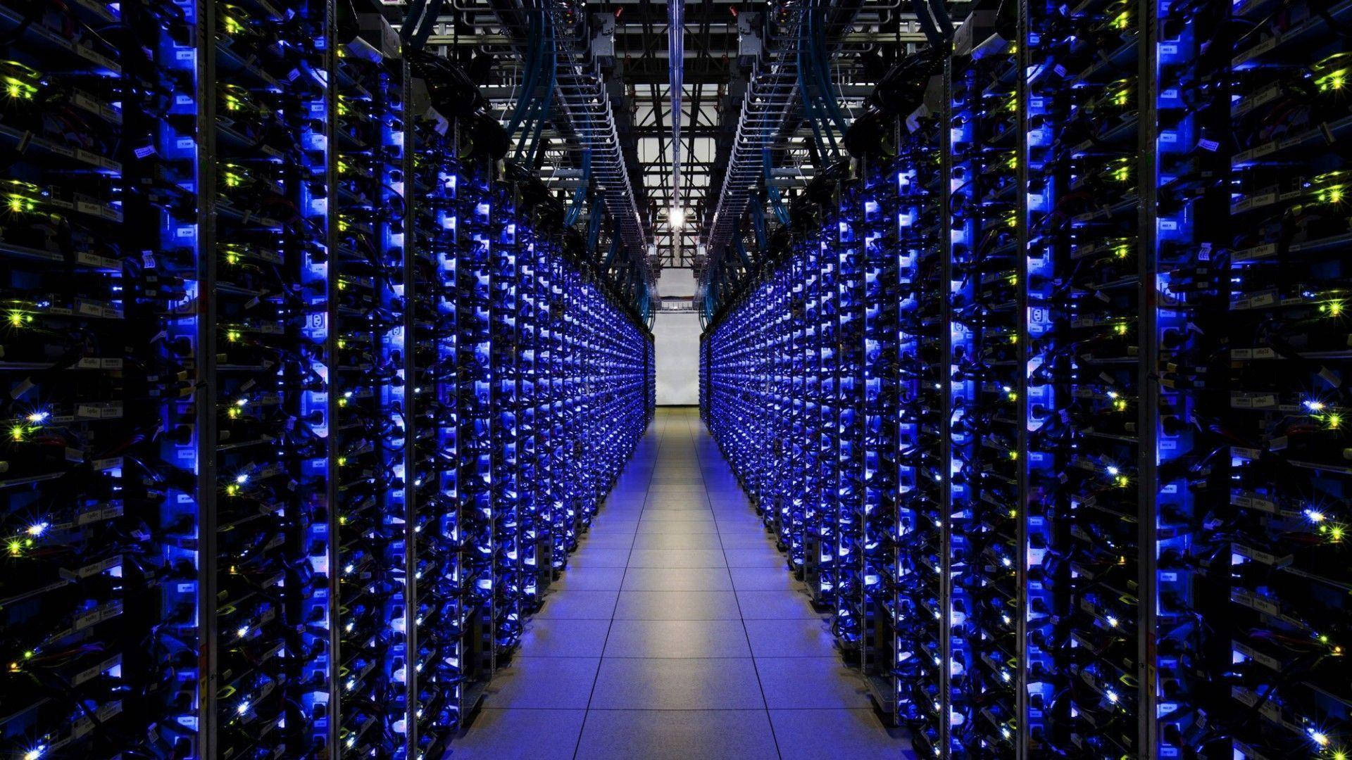 data 桌布 壁紙 — 數據中心內一條長長的伺服器機架走廊，發出藍色和黃色的光芒。