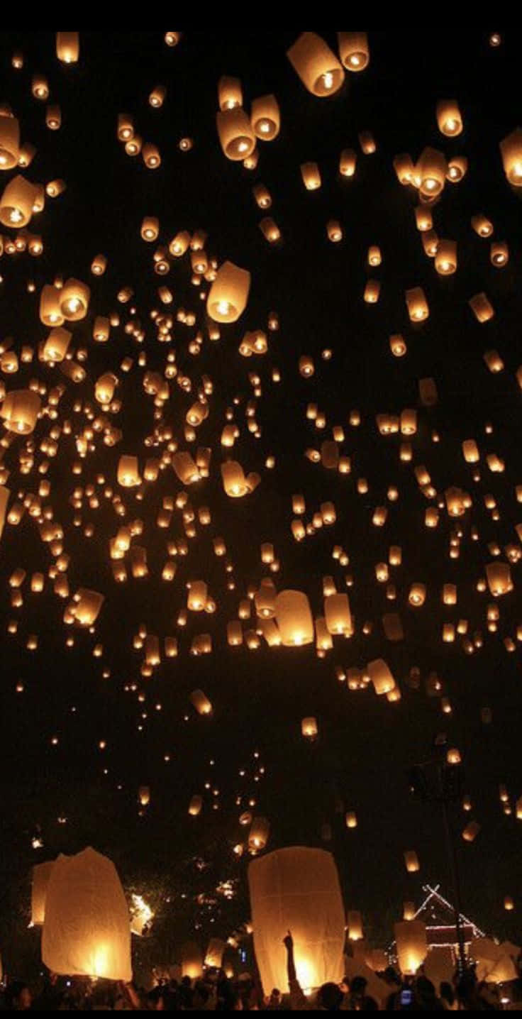 Lantern 桌布 壁紙 — 數百盞發光的天燈在慶祝活動中升入人群上方的黑暗夜空。