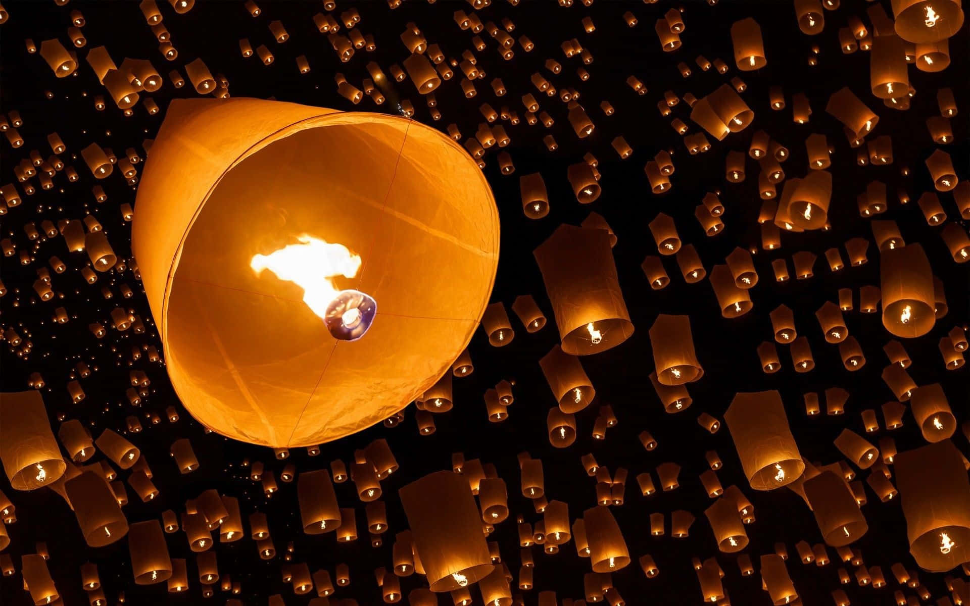 Lantern 桌布 壁紙 — 數百盞發光的天燈在漆黑的夜空中向上飄浮，營造出溫暖神奇的氛圍。