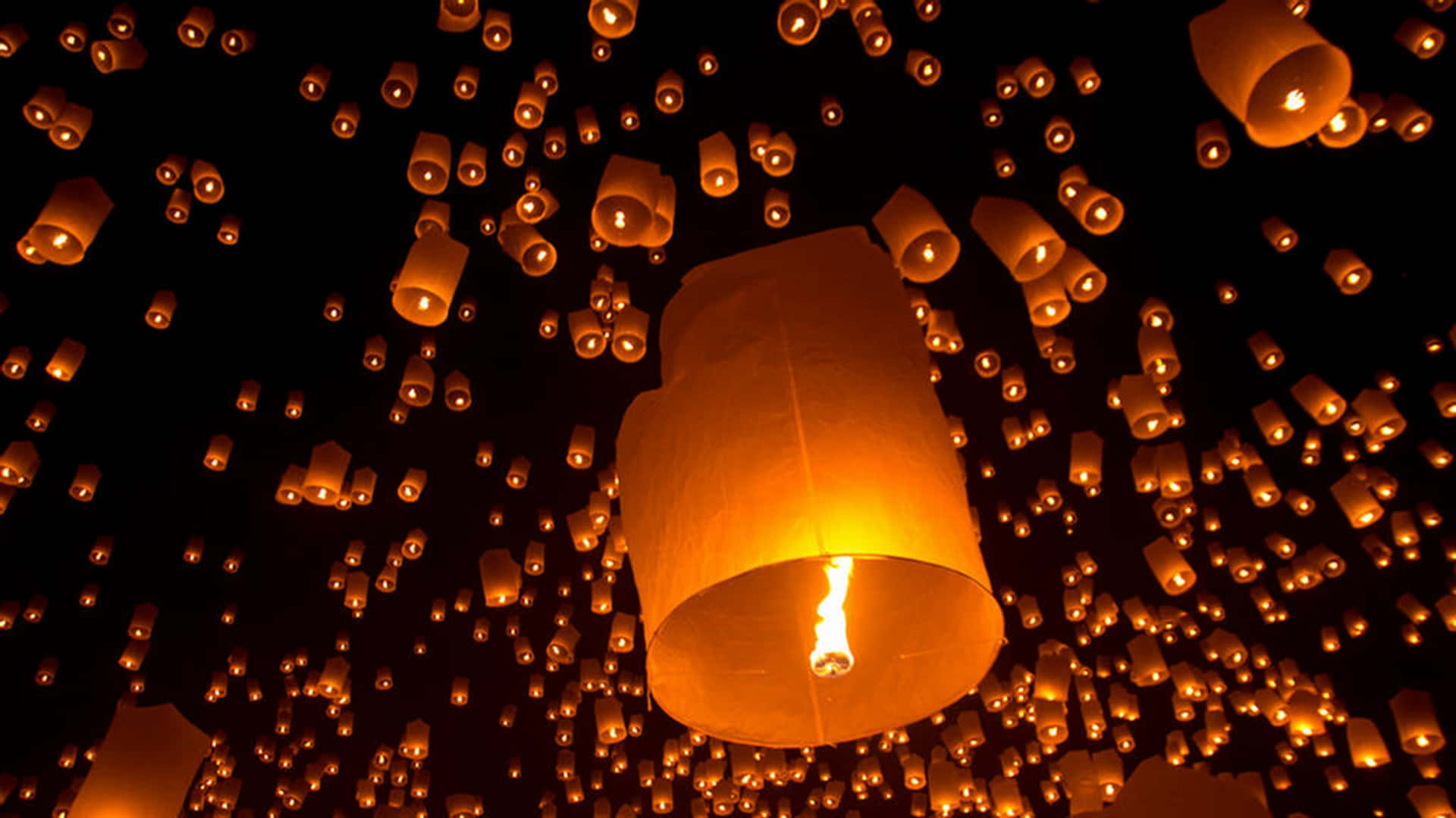 Lantern 桌布 壁紙 — 數百盞發光的橙色天燈升入黑暗的夜空，營造出溫暖神奇的氛圍。
