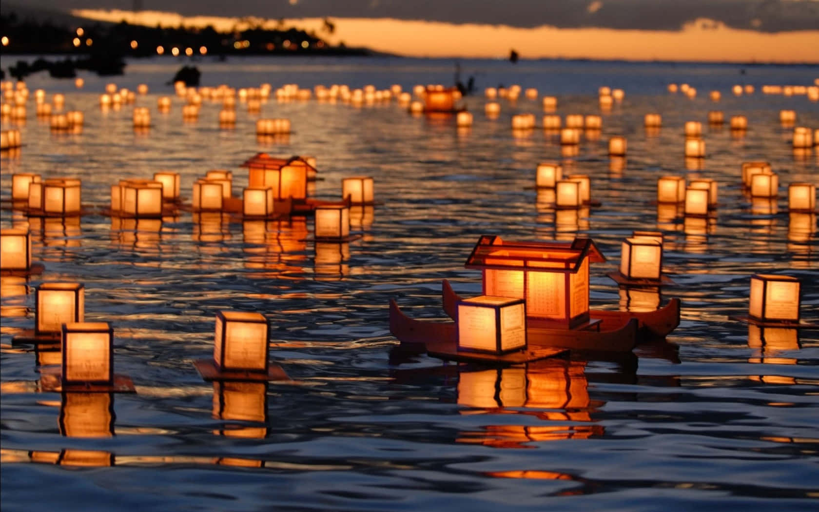 Lantern 桌布 壁紙 — 數百盞發光的紙燈籠在日落時分靜靜地漂浮在平靜的水面上，投射出溫暖的倒影。