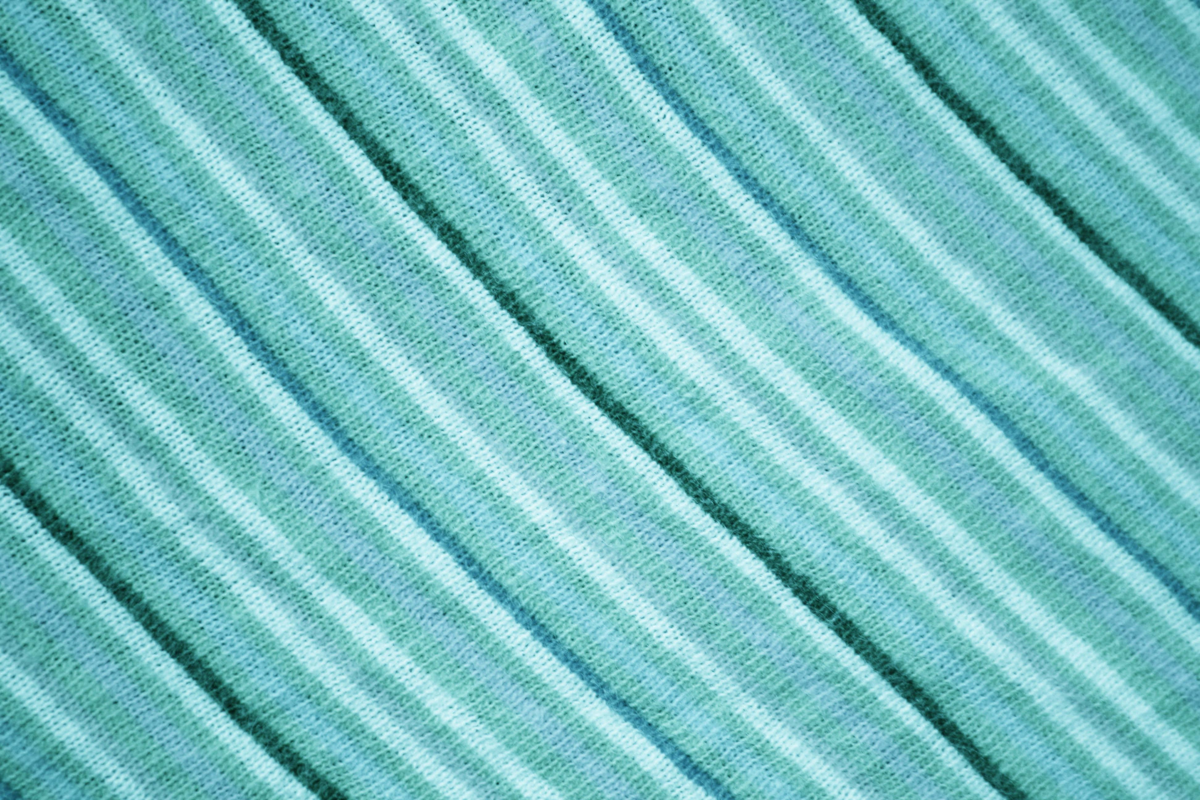 Fabric 桌布 壁紙 — 斜紋青綠色和白色針織布料的特寫，具有可見紋理和柔和光線。
