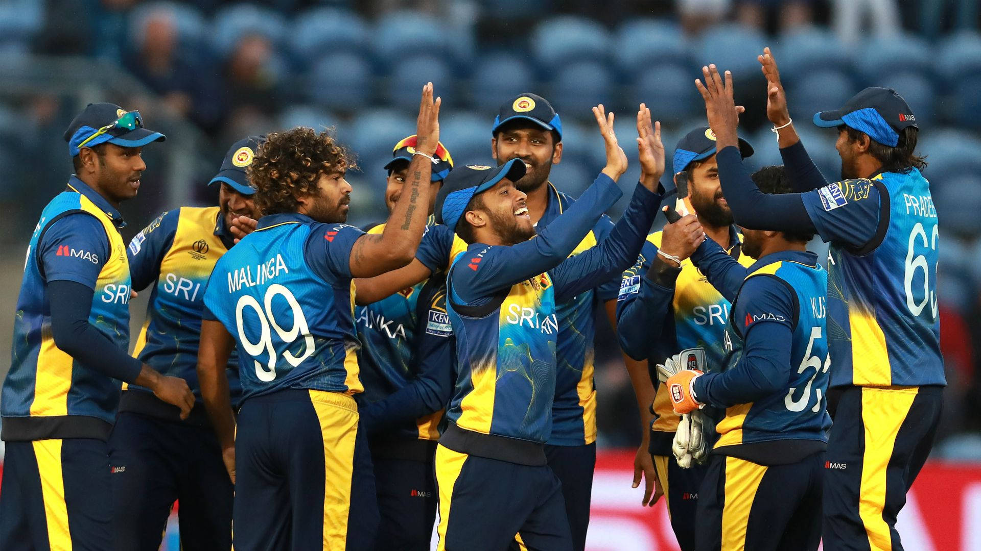 Sri Lanka Cricket 桌布 壁紙 — 斯里蘭卡板球隊球員身穿藍黃色球衣在球場上擊掌慶祝。