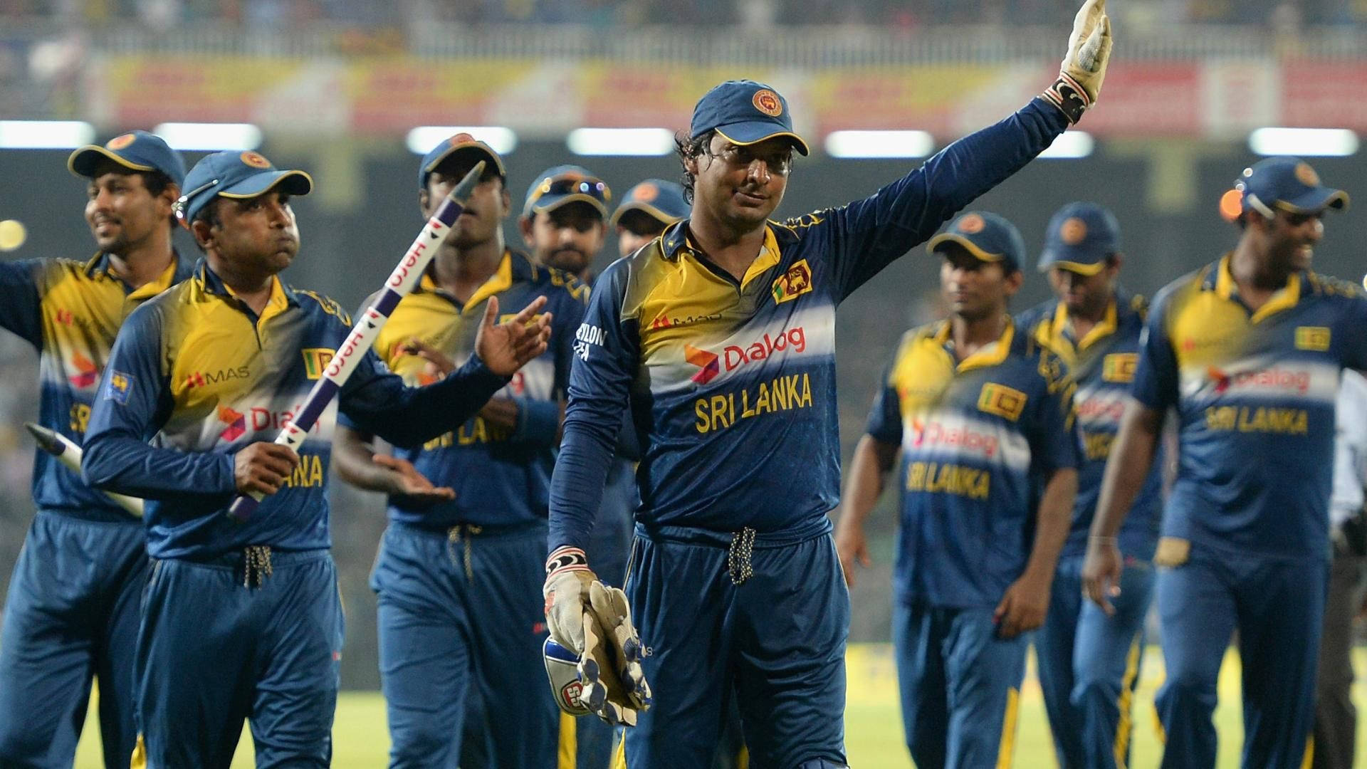 Sri Lanka Cricket 桌布 壁紙 — 斯里蘭卡板球隊球員身穿藍黃色球衣，在夜間球場的明亮燈光下慶祝。