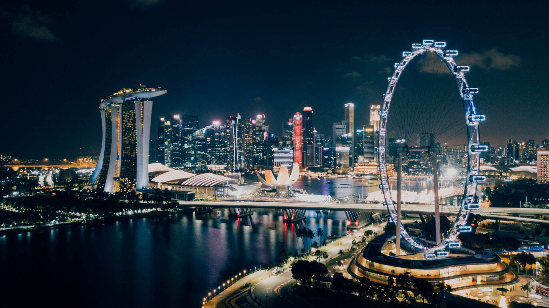 Singapore 桌布 壁紙 — 新加坡天際線的迷人夜景，濱海灣金沙和新加坡摩天觀景輪在黑暗的天空下閃耀。
