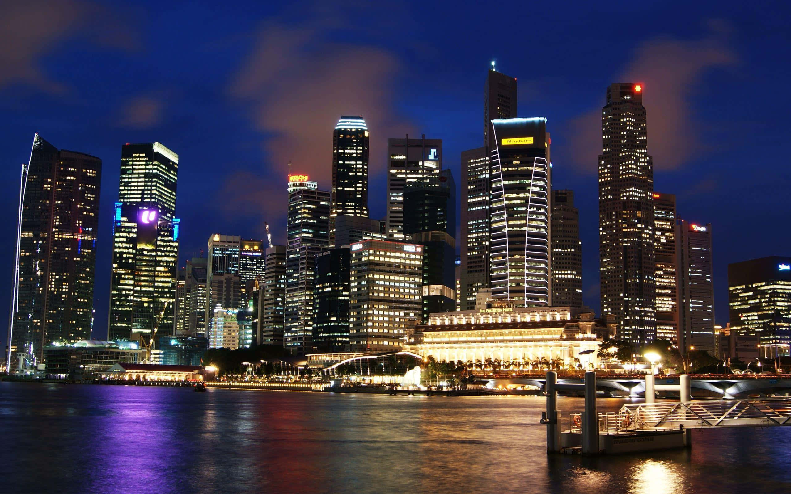 Singapore 桌布 壁紙 — 新加坡天際線的迷人夜景，燈火通明的摩天大樓倒映在平靜的水面上。