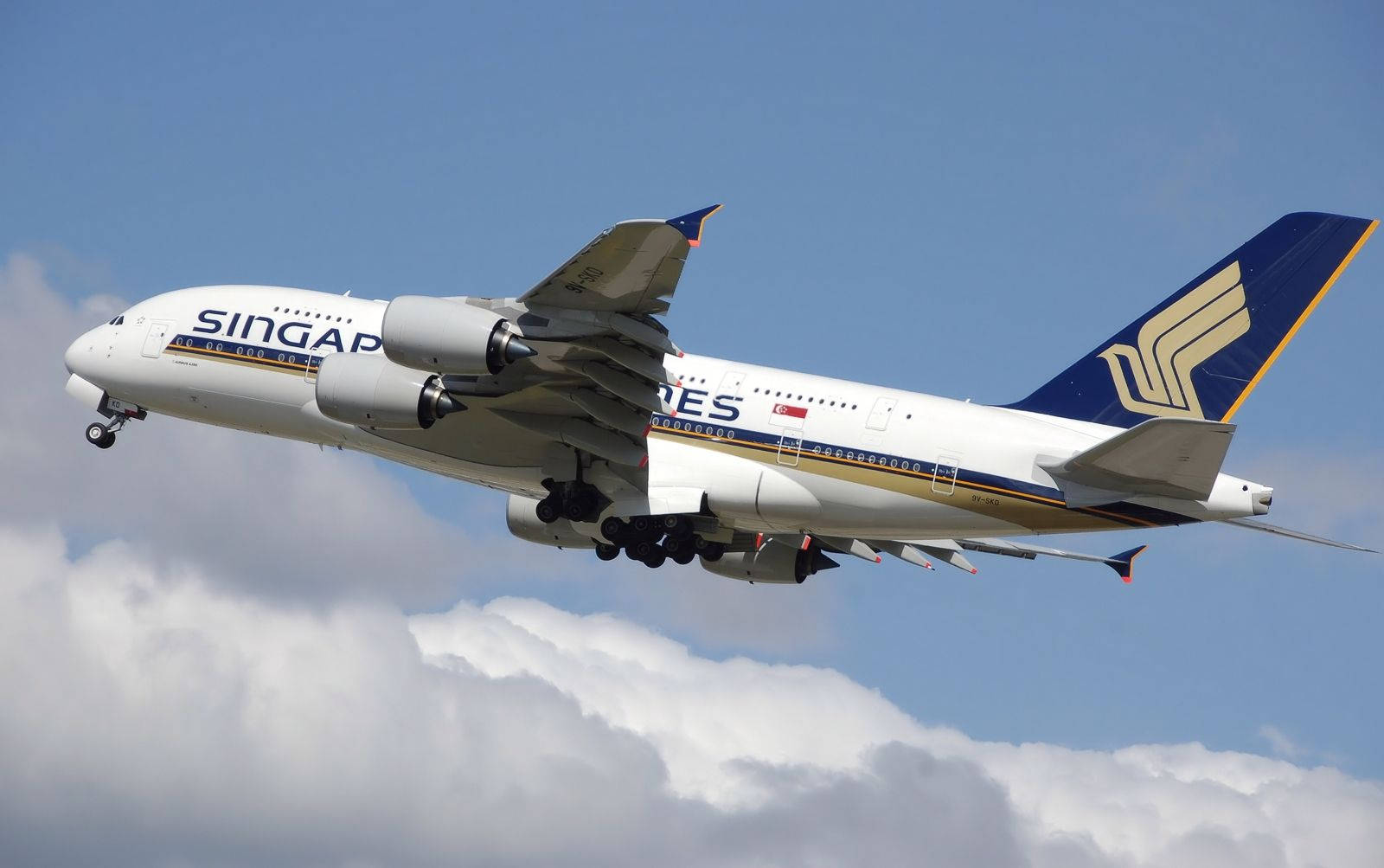 飛機 桌布 壁紙 — 新加坡航空的空中巴士A380在晴朗的藍天中穿過蓬鬆的白雲下降。