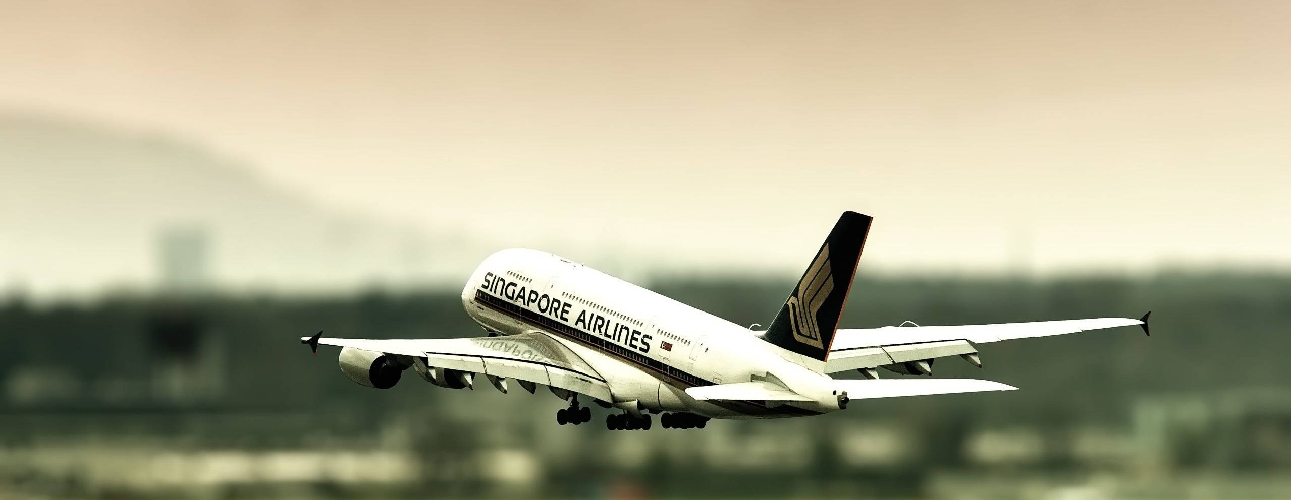 Singapore 桌布 壁紙 — 新加坡航空的空中巴士A380在朦朧的天空下起飛，遠處是模糊的城市景觀和山丘。