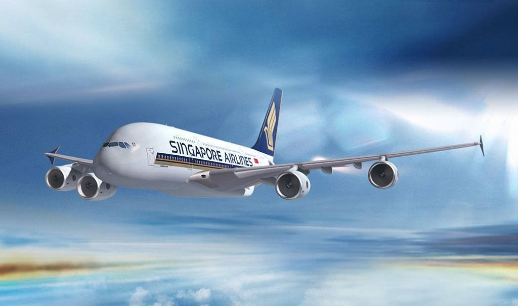 飛機 桌布 壁紙 — 新加坡航空的空中巴士A380在蔚藍天空中優雅翱翔，伴隨著縷縷雲彩和下方的彩虹光芒。