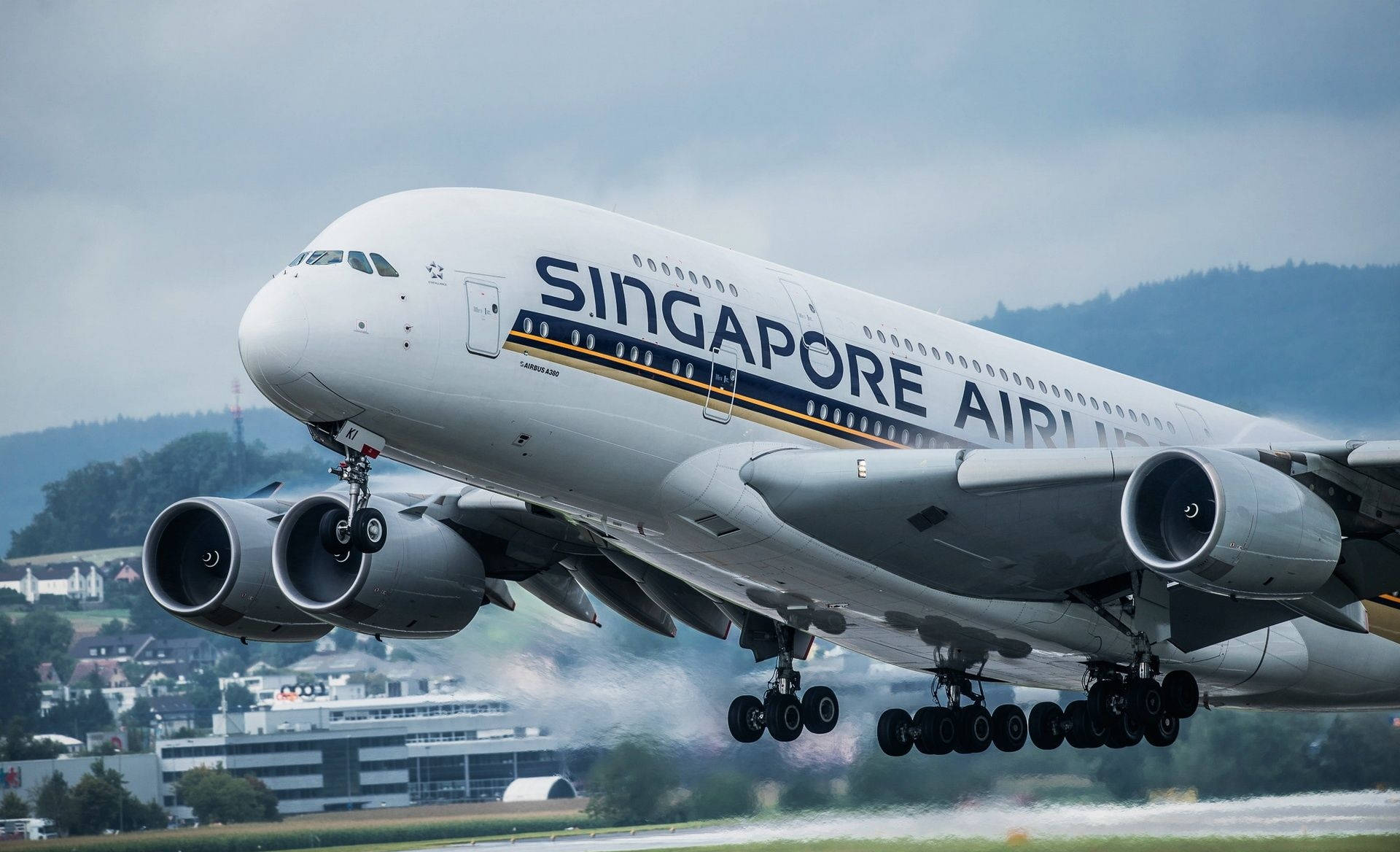 機場 桌布 壁紙 — 新加坡航空的空中巴士A380在陰天和遠山背景下放下起落架起飛。