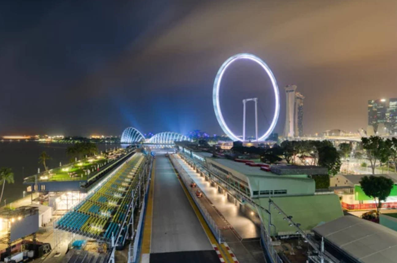 4K 桌布 壁紙 — 新加坡賽車場的充滿活力的夜景，標誌性的新加坡摩天輪在背景中閃耀。