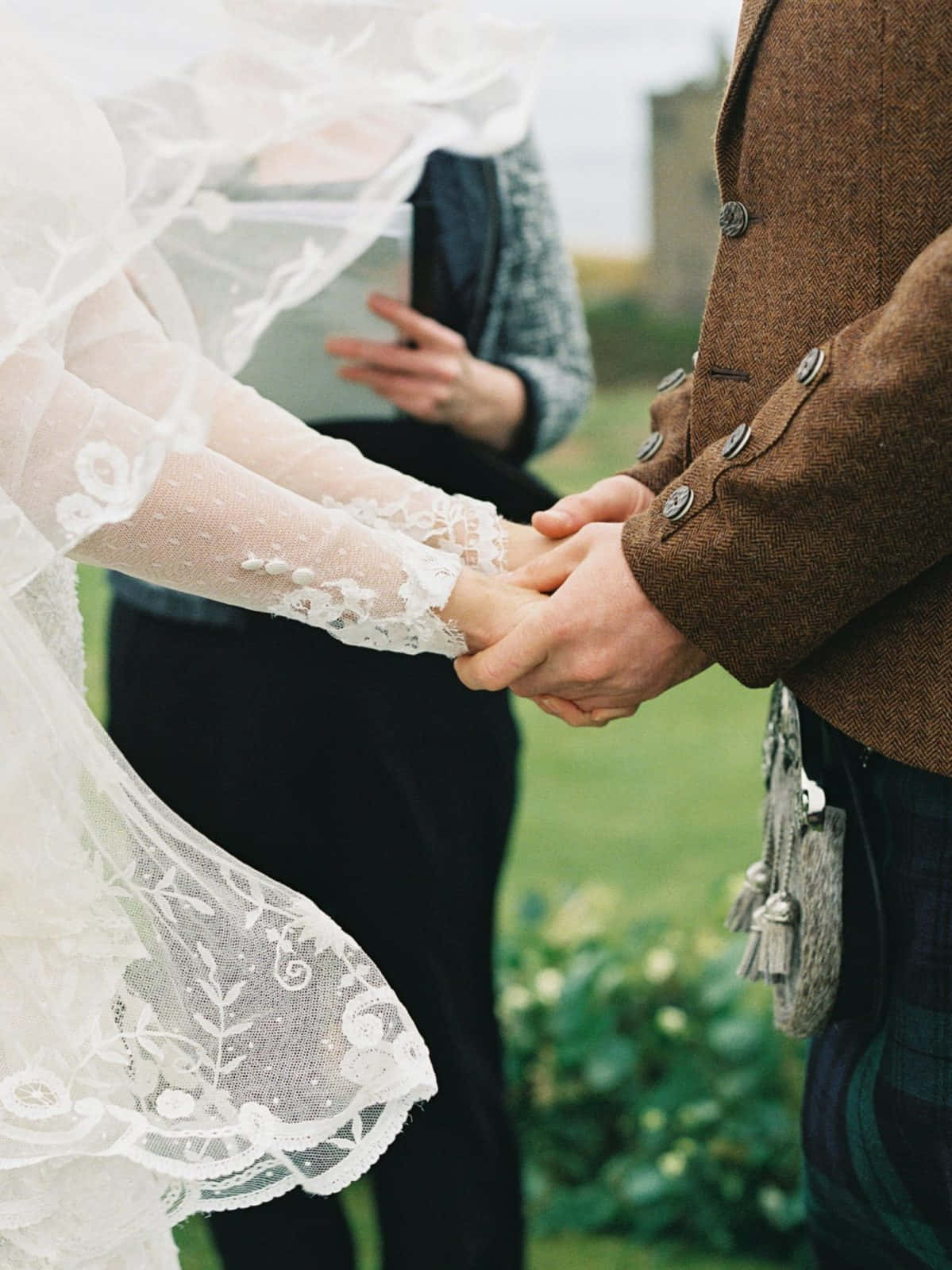 Holding Hands 桌布 壁紙 — 新娘和新郎在戶外溫馨時刻牽手，蕾絲頭紗和蘇格蘭裙清晰可見。