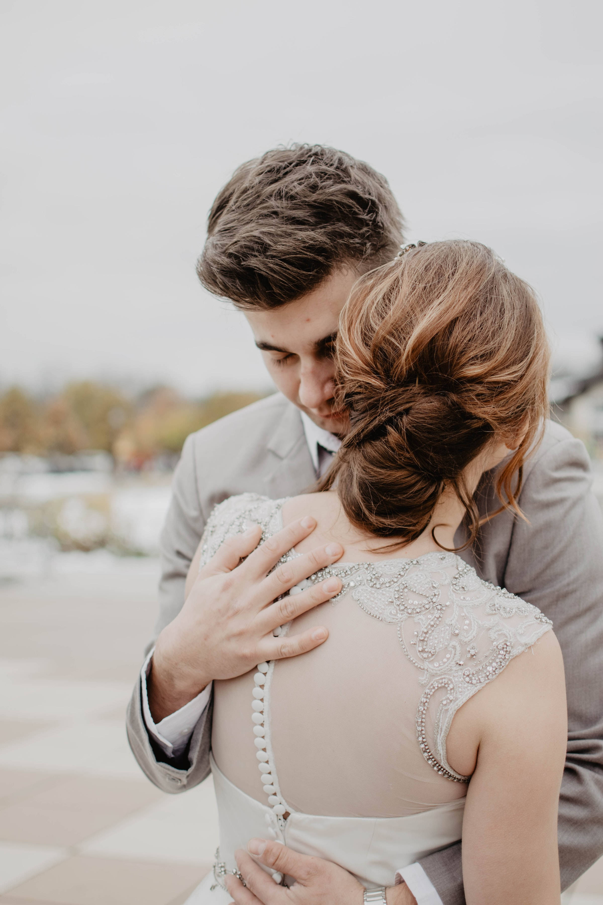 married 桌布 壁紙 — 新娘和新郎在柔和光線的戶外環境中，以柔和的秋色調溫柔擁抱。